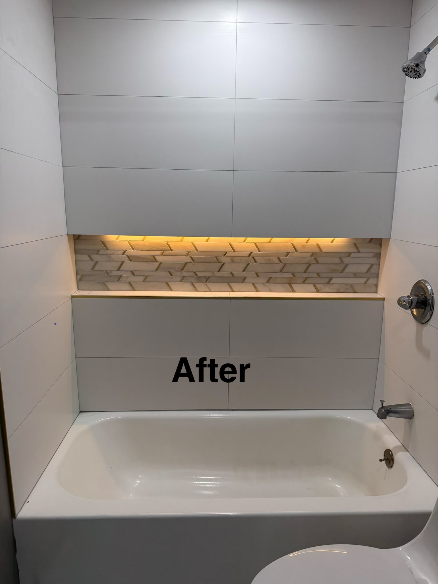 Completed modern bathtub renovation with large format wall tile and LED-illuminated mosaic niche by LQJ General Construction in Smithtown NY