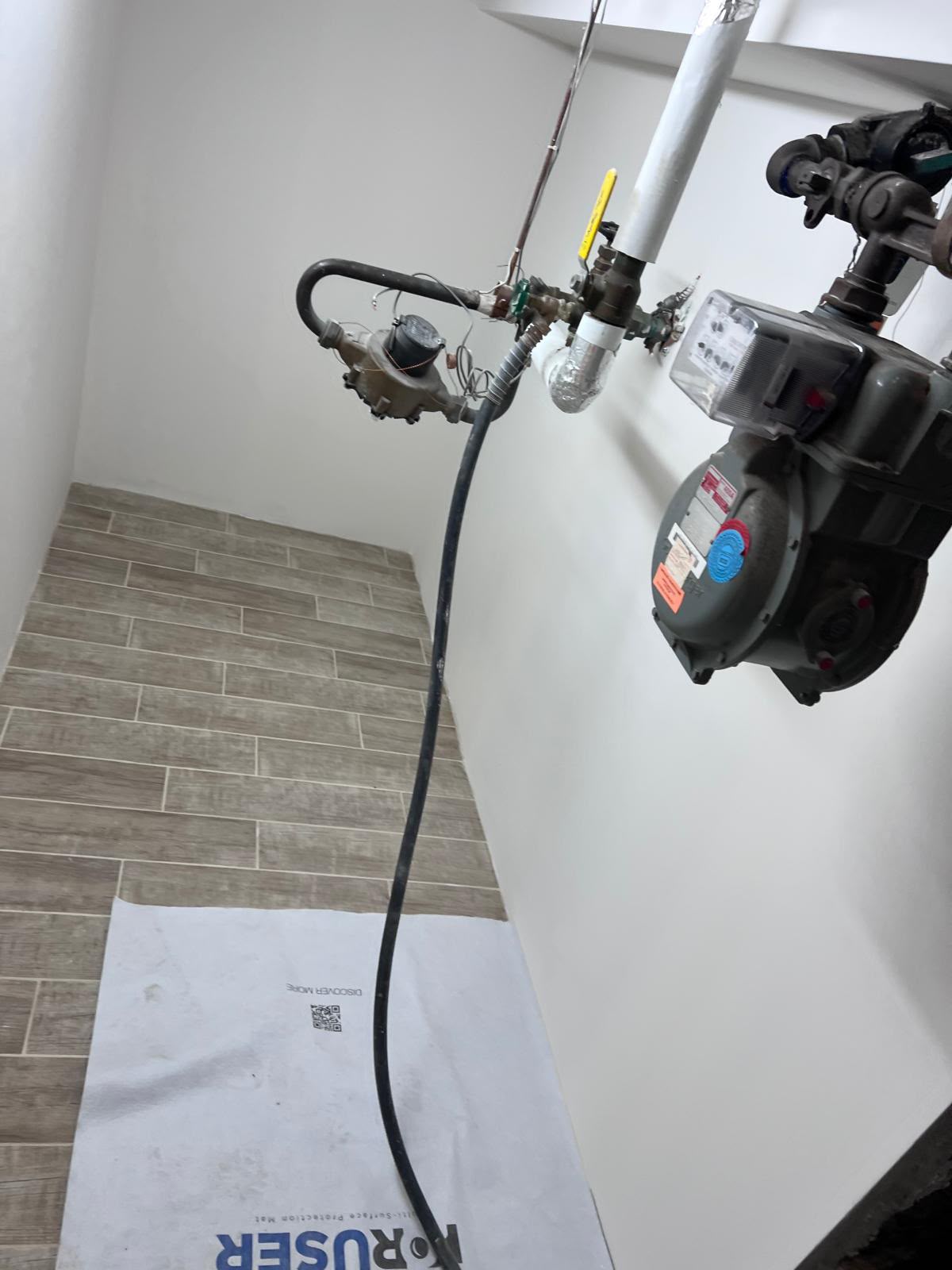 Wood-grain porcelain tile floor and clean mechanical utility room by LQJ General Construction in Central Islip NY