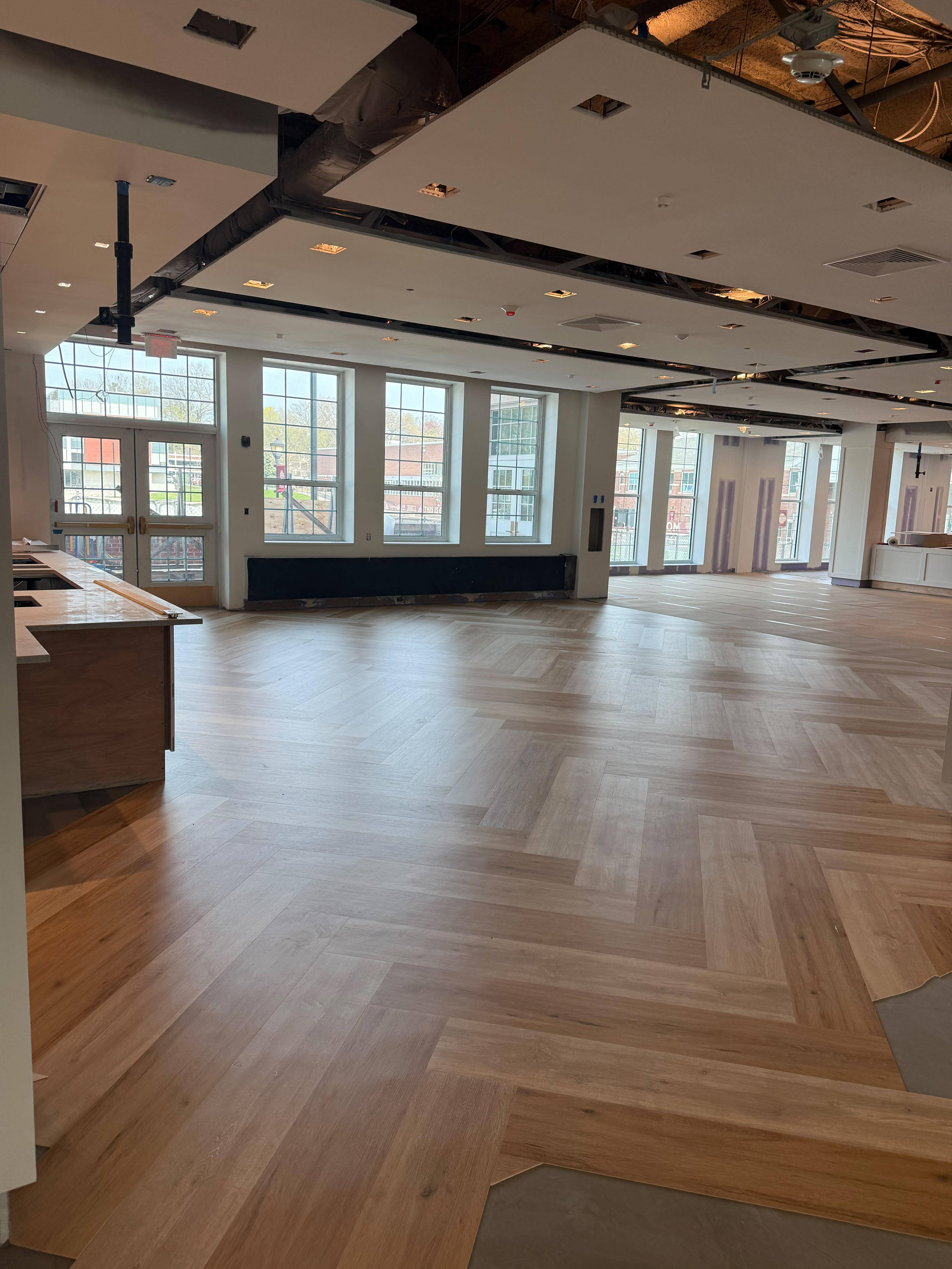 Expansive herringbone pattern luxury wood plank flooring completed in modern commercial lounge by LQJ General Construction in Hauppauge NY