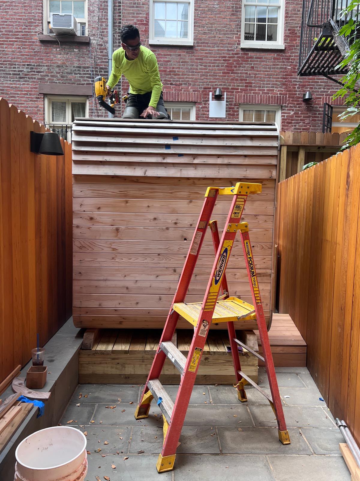LQJ General Construction carpenter nailing western red cedar siding slats on curved outdoor sauna roof