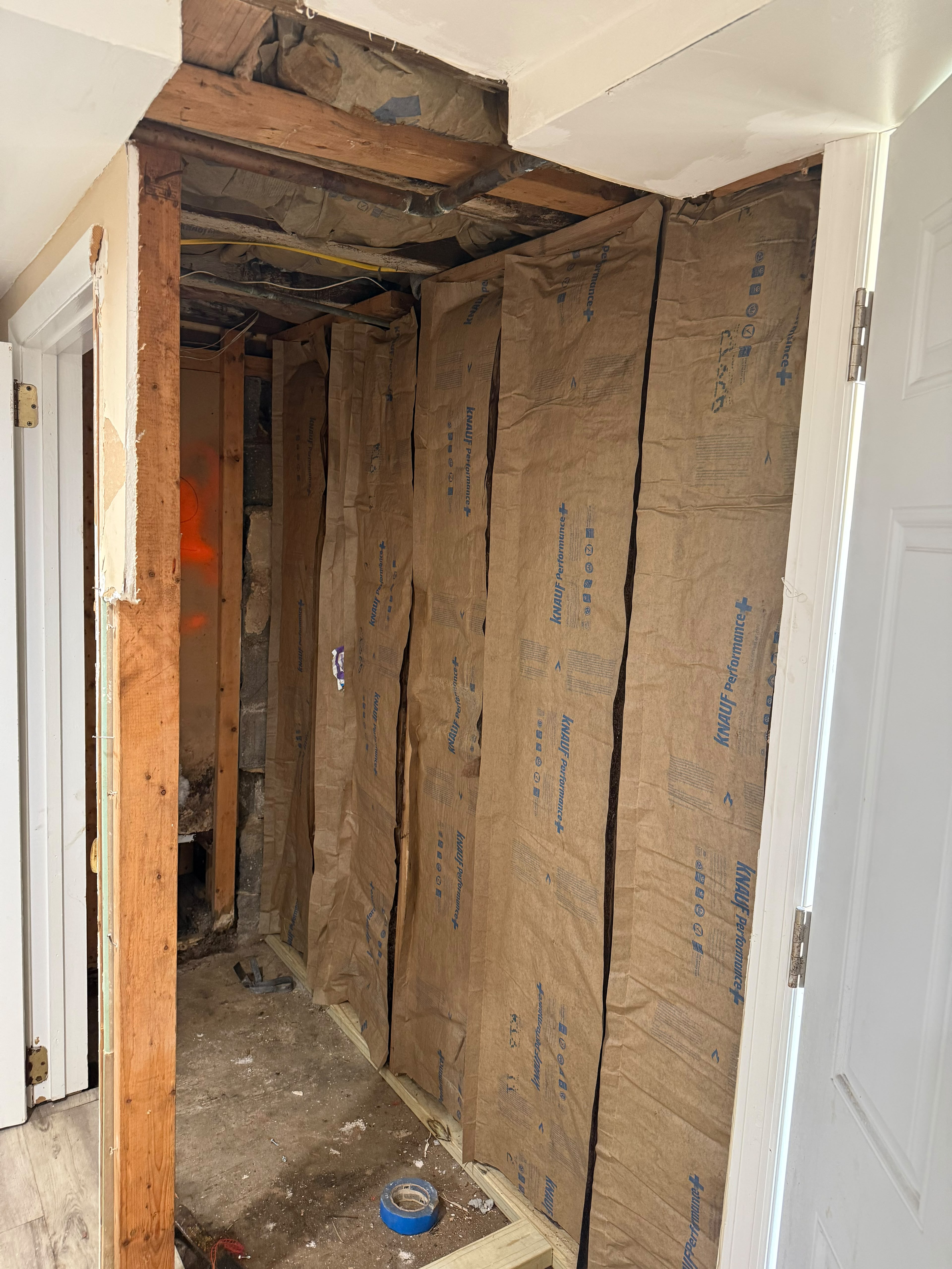 Continuous Knauf Performance kraft-faced fiberglass batt insulation installed between studs by LQJ General Construction