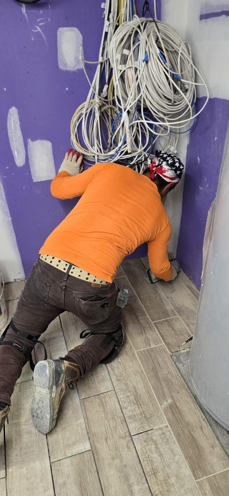 LQJ General Construction installer hand-floating grout on wood-grain porcelain tile floor in East Northport NY