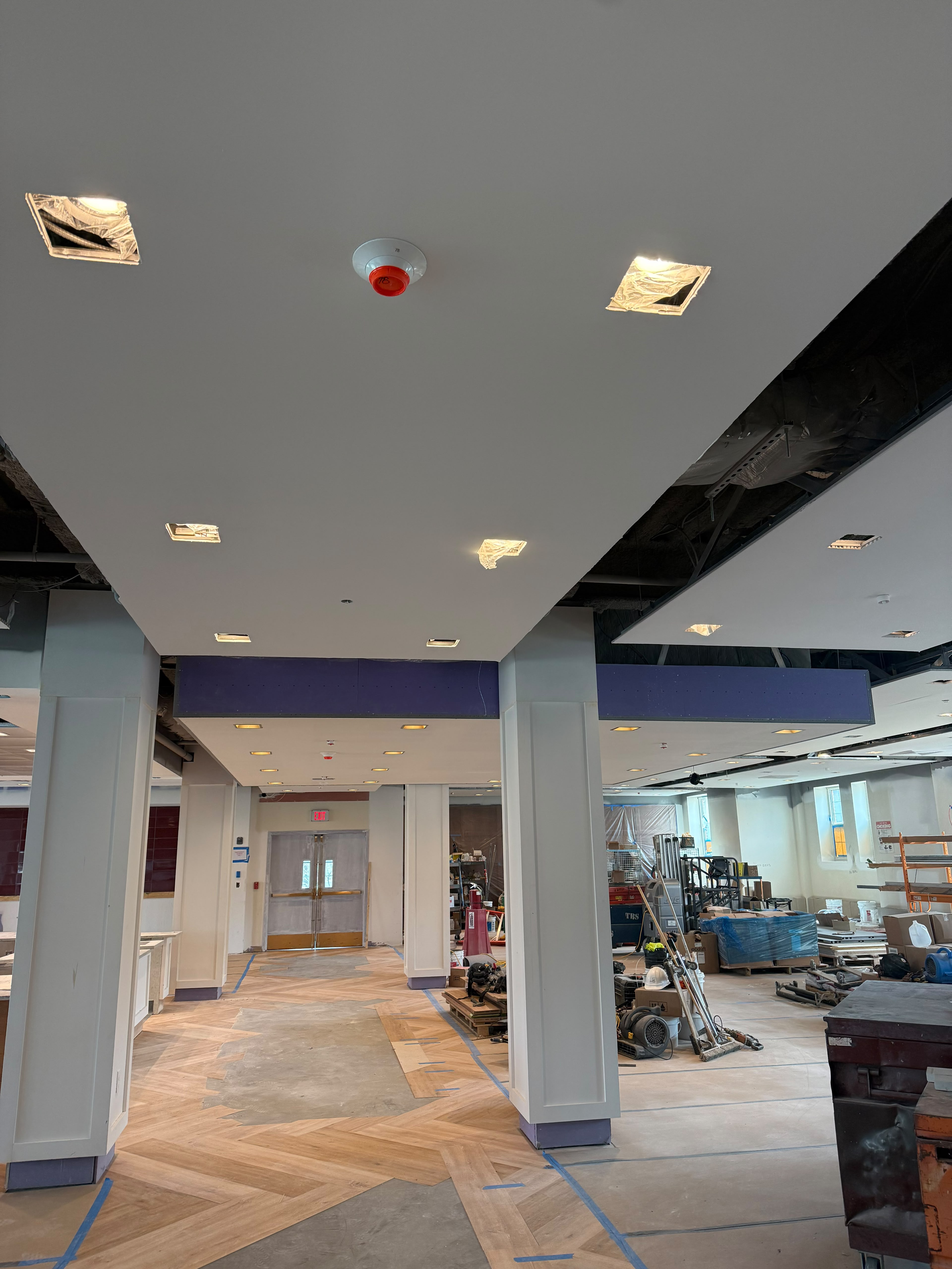 Completed commercial hallway drywall columns, floating ceiling panels, and herringbone floor by LQJ General Construction in Hauppauge NY