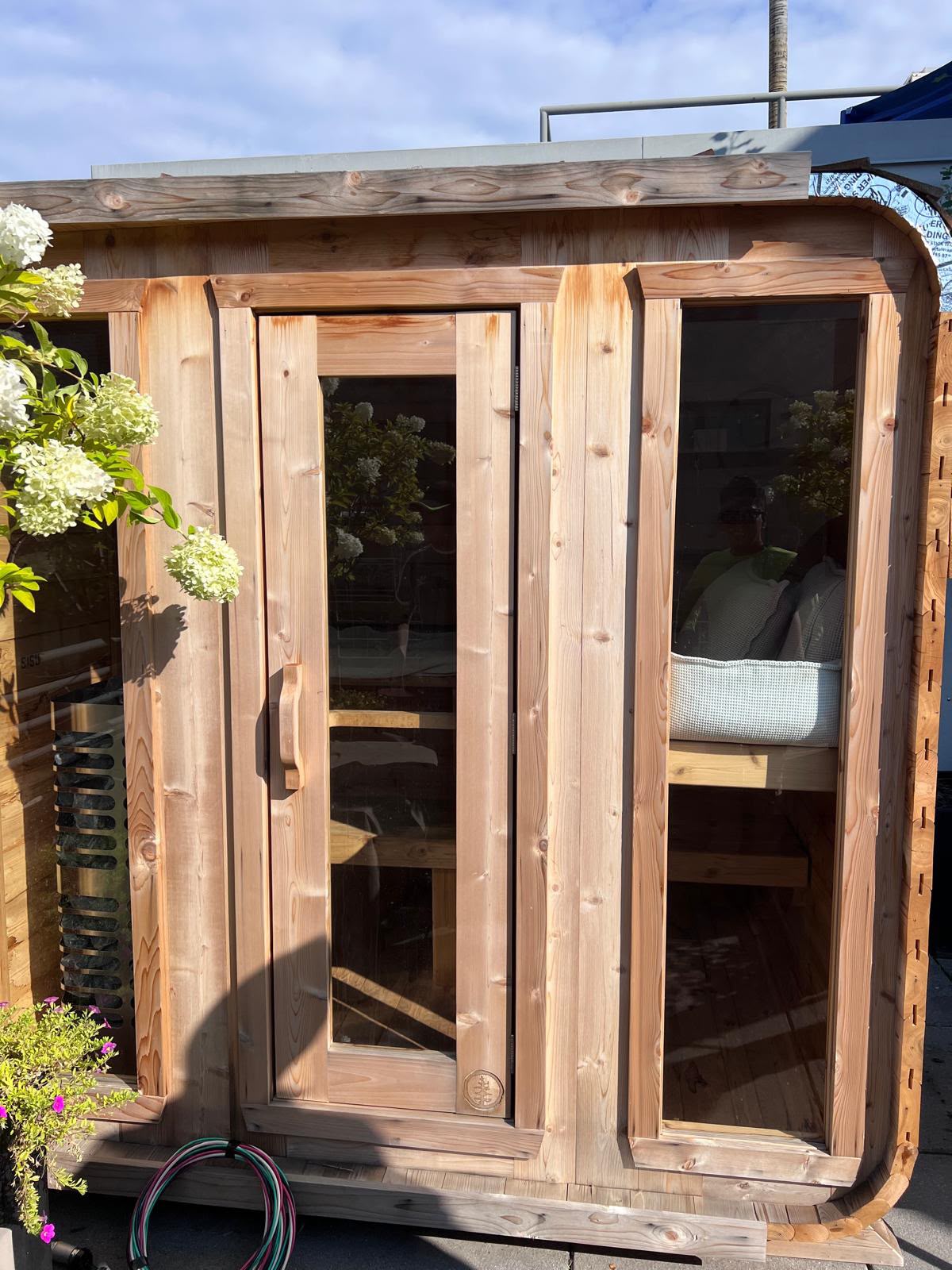 Completed outdoor western red cedar sauna with insulated glass door and viewing windows by LQJ General Construction in Northport NY