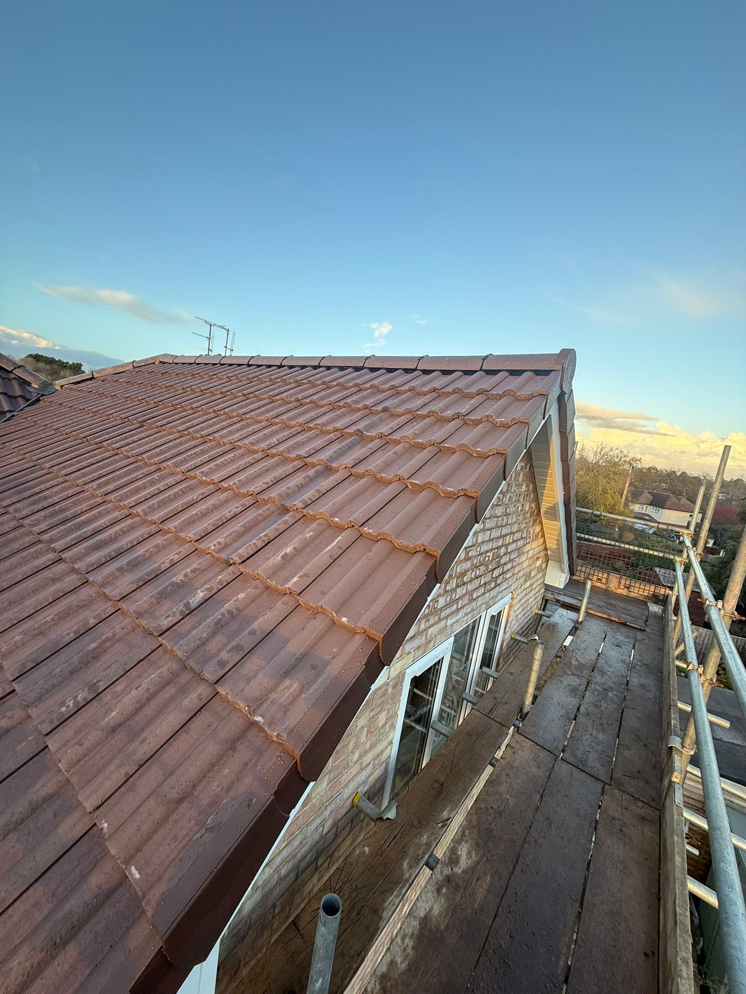 Interlocking tiled roof with maintenance-free dry verge system