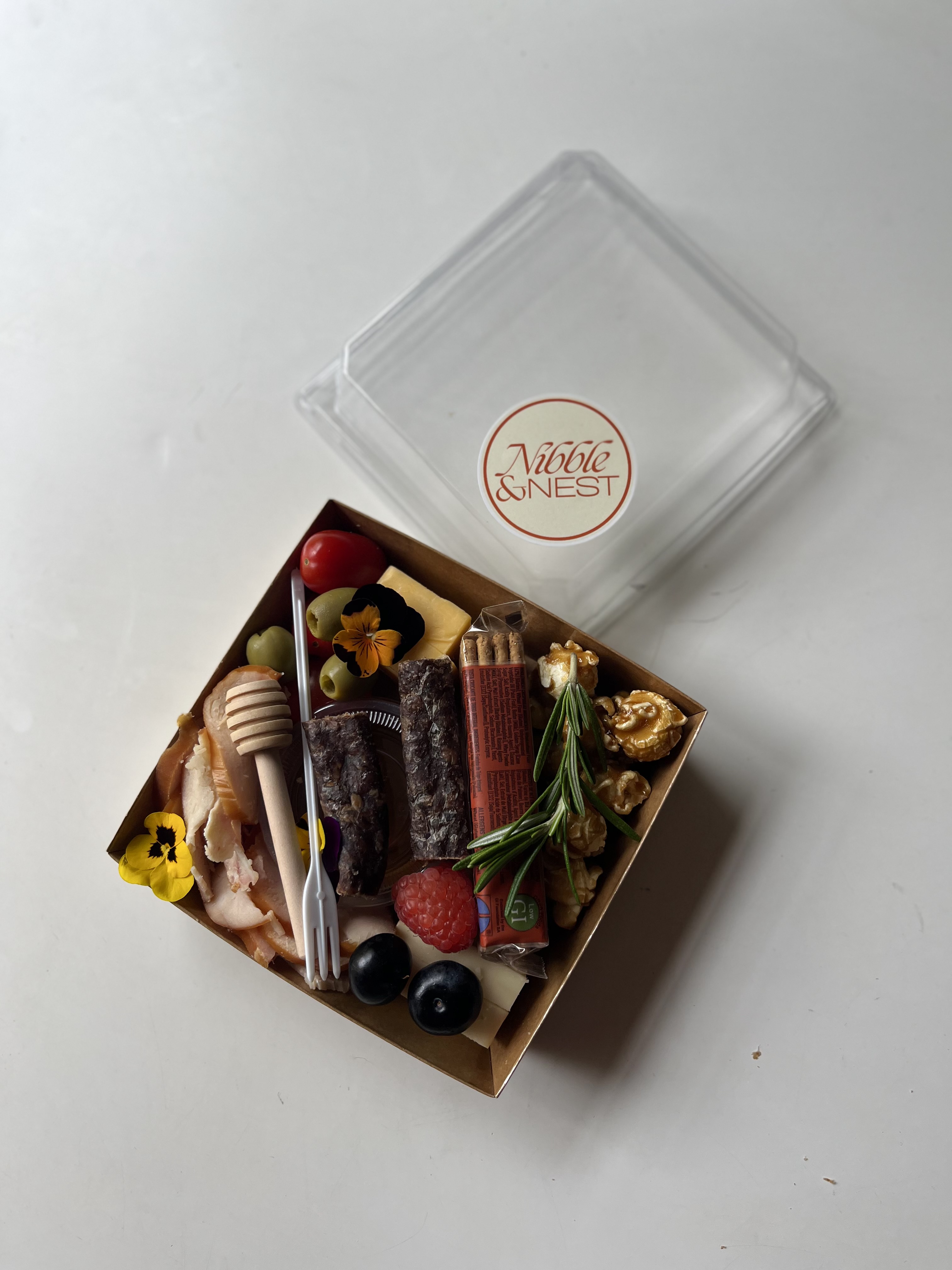 A single Nibble & Nest charcuterie box ready to gift