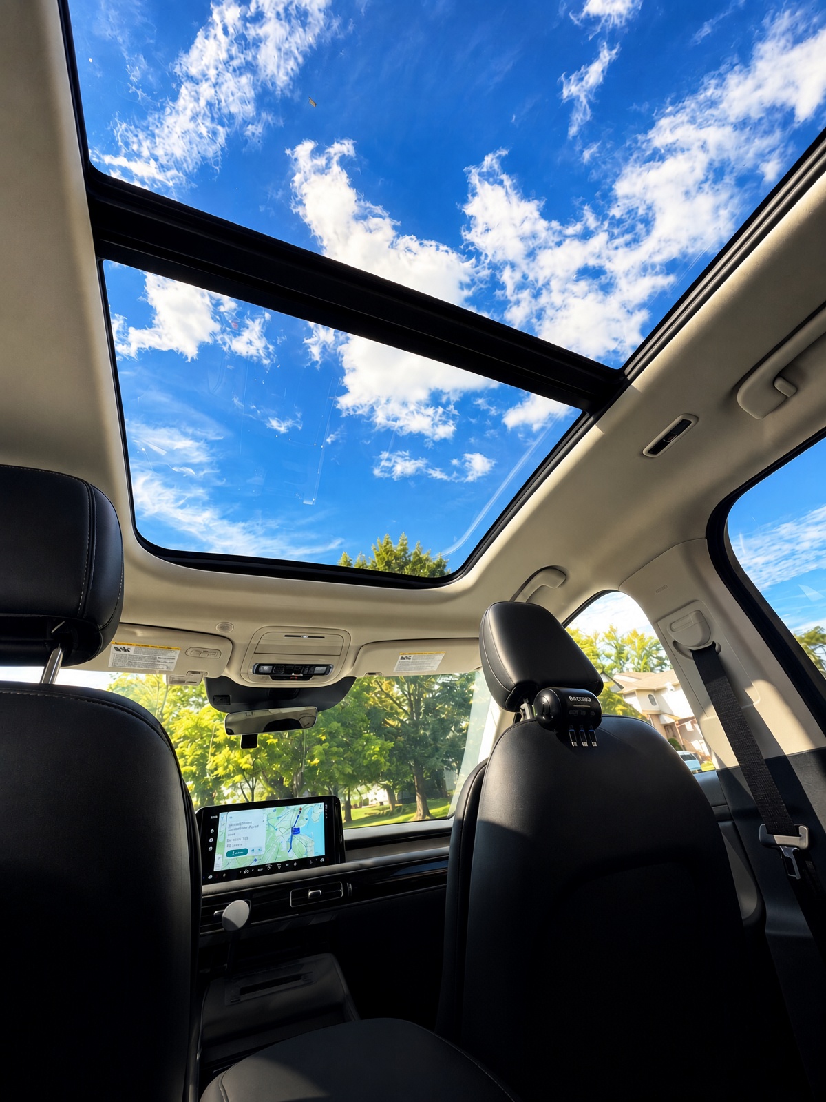 Dual panoramic glass sunroof of Lincoln Aviator looking up at blue sky and clouds