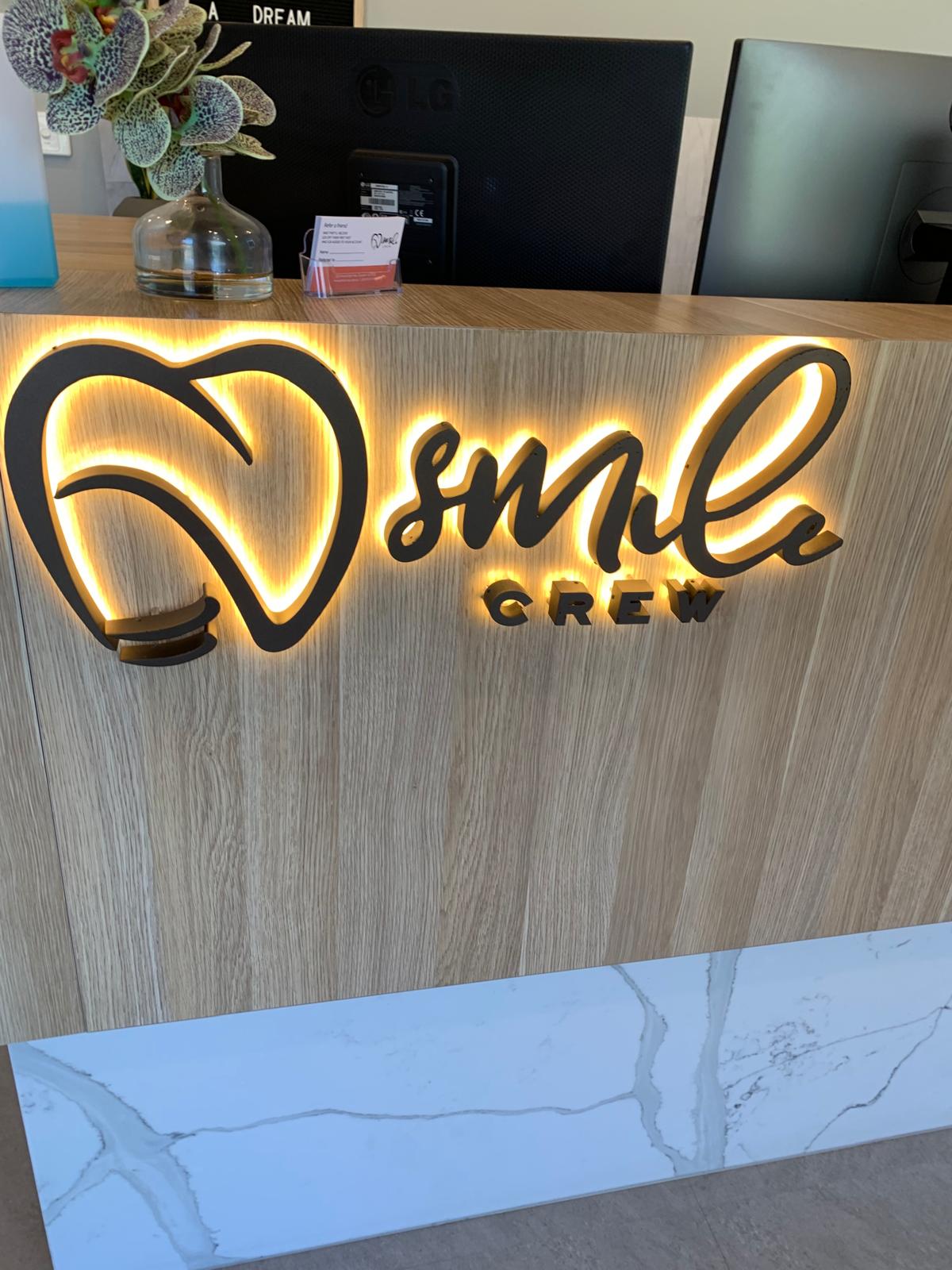 Smile Crew illuminated reception desk and brand sign in Croydon