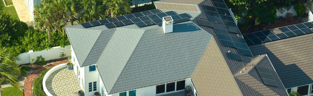 Aerial view of completed residential roof replacement with solar panels in Southwest Florida