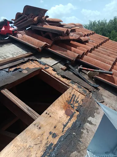Tile roof replacement underway showing underlayment and deck repair