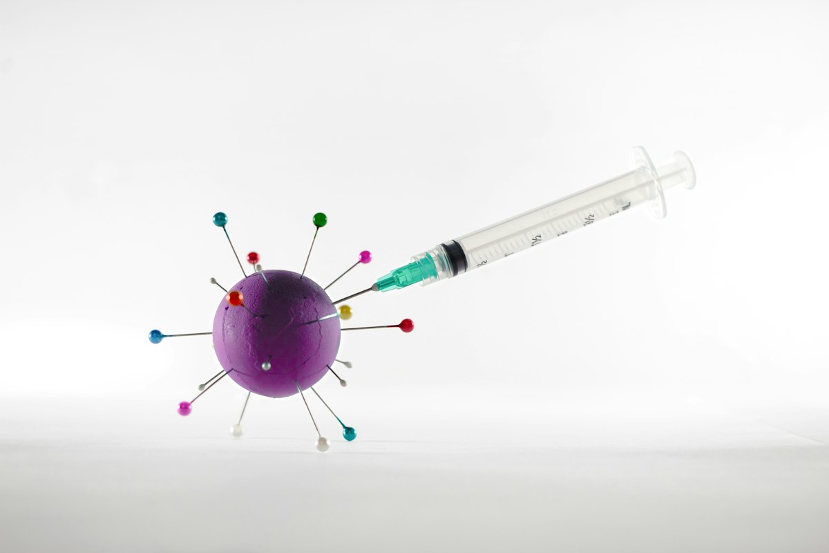 Jeringa y vial de vacuna sobre superficie clínica, imagen referente a prevención de VPH