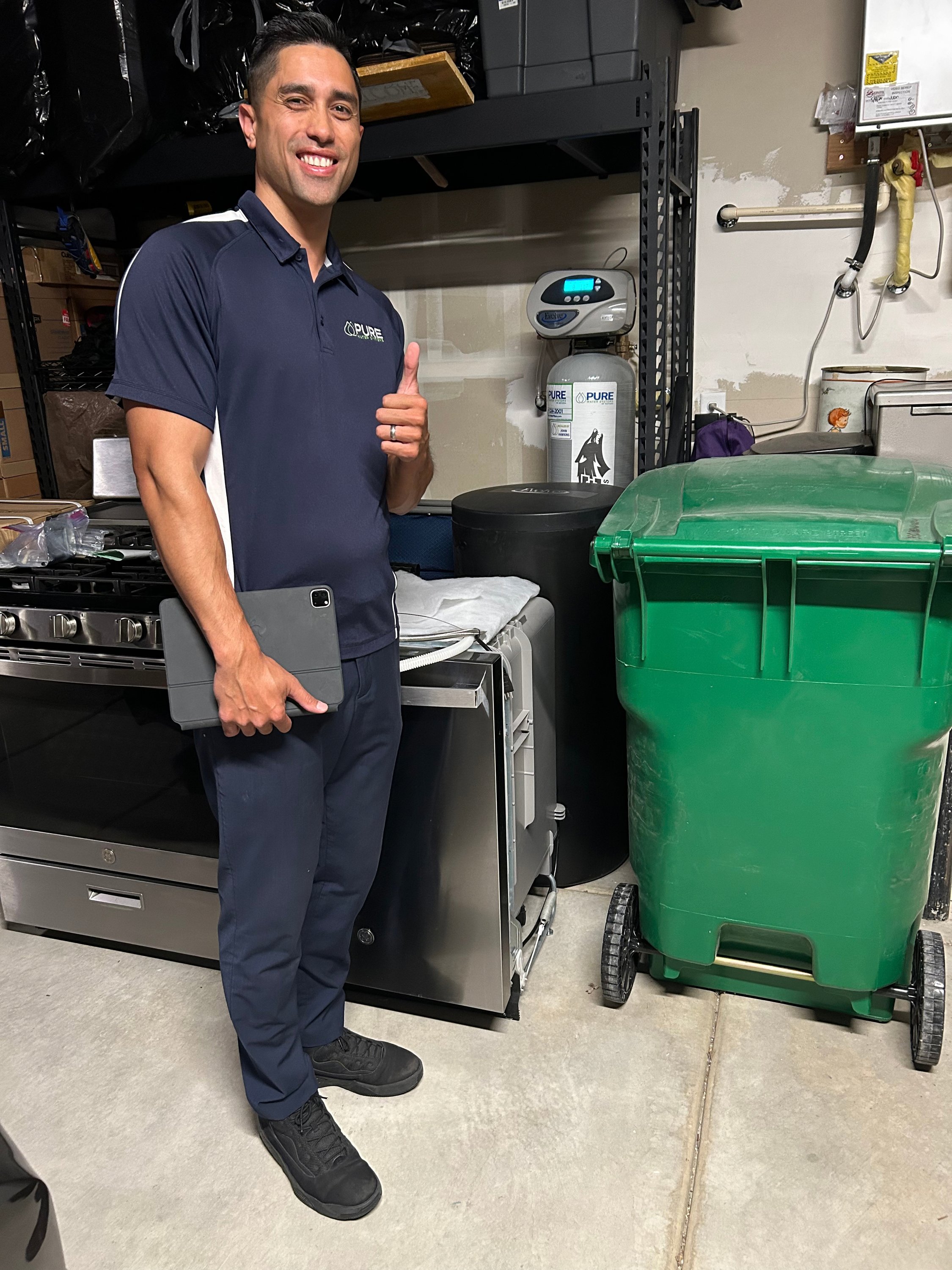 Kawika Burdine in polo with tablet after completing an on-site installation review