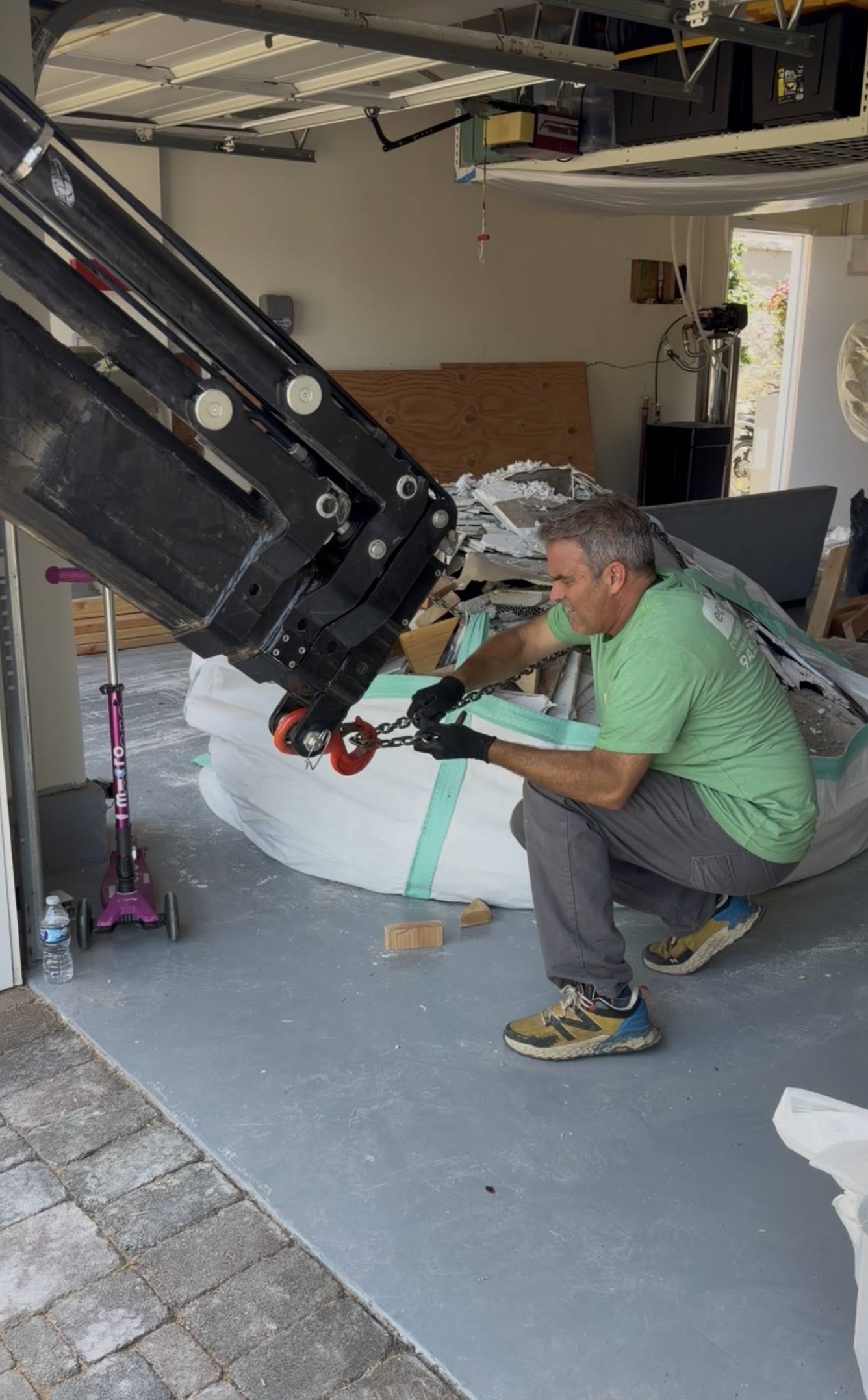 Eco Waste crew member rigging a heavy-duty dumpster bag for crane hoist