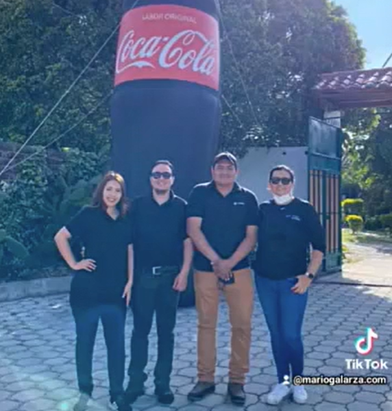 Mario Galarza con el equipo de Coca-Cola junto a la botella inflable gigante