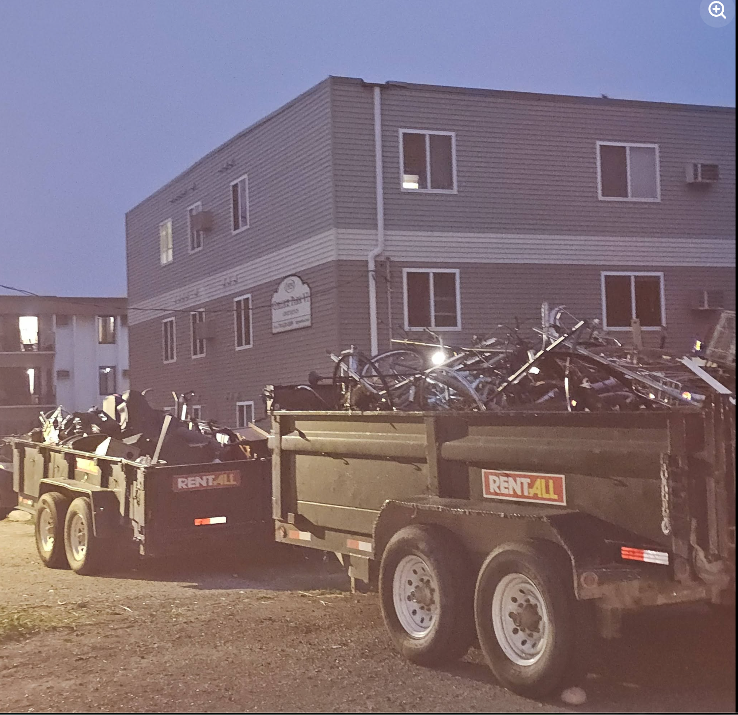 Dual heavy dump trailers loaded to the brim with metal scrap and cleanout debris