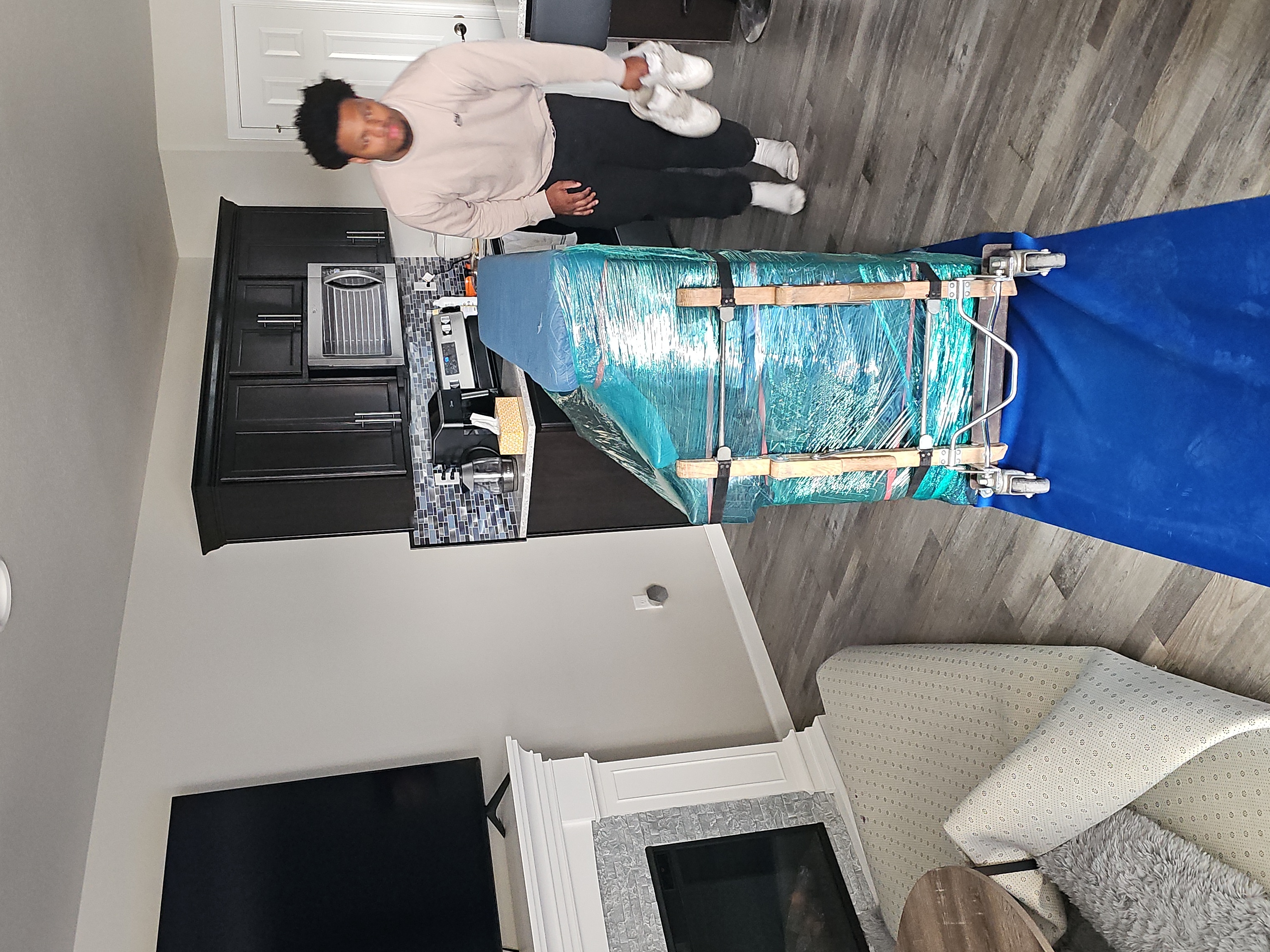 Painless Path Movers crew member moving wrapped furniture on a dolly with padded blankets