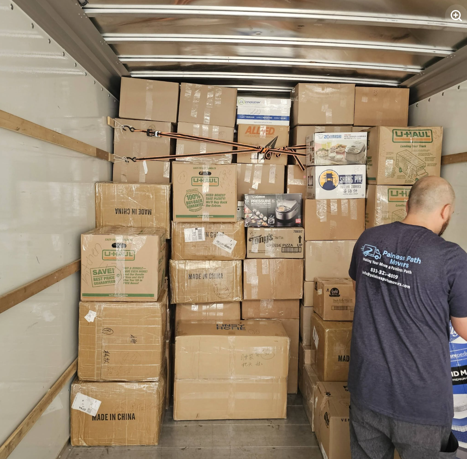 Painless Path Movers crew loading a truck floor-to-ceiling with carefully stacked and strapped boxes and furniture