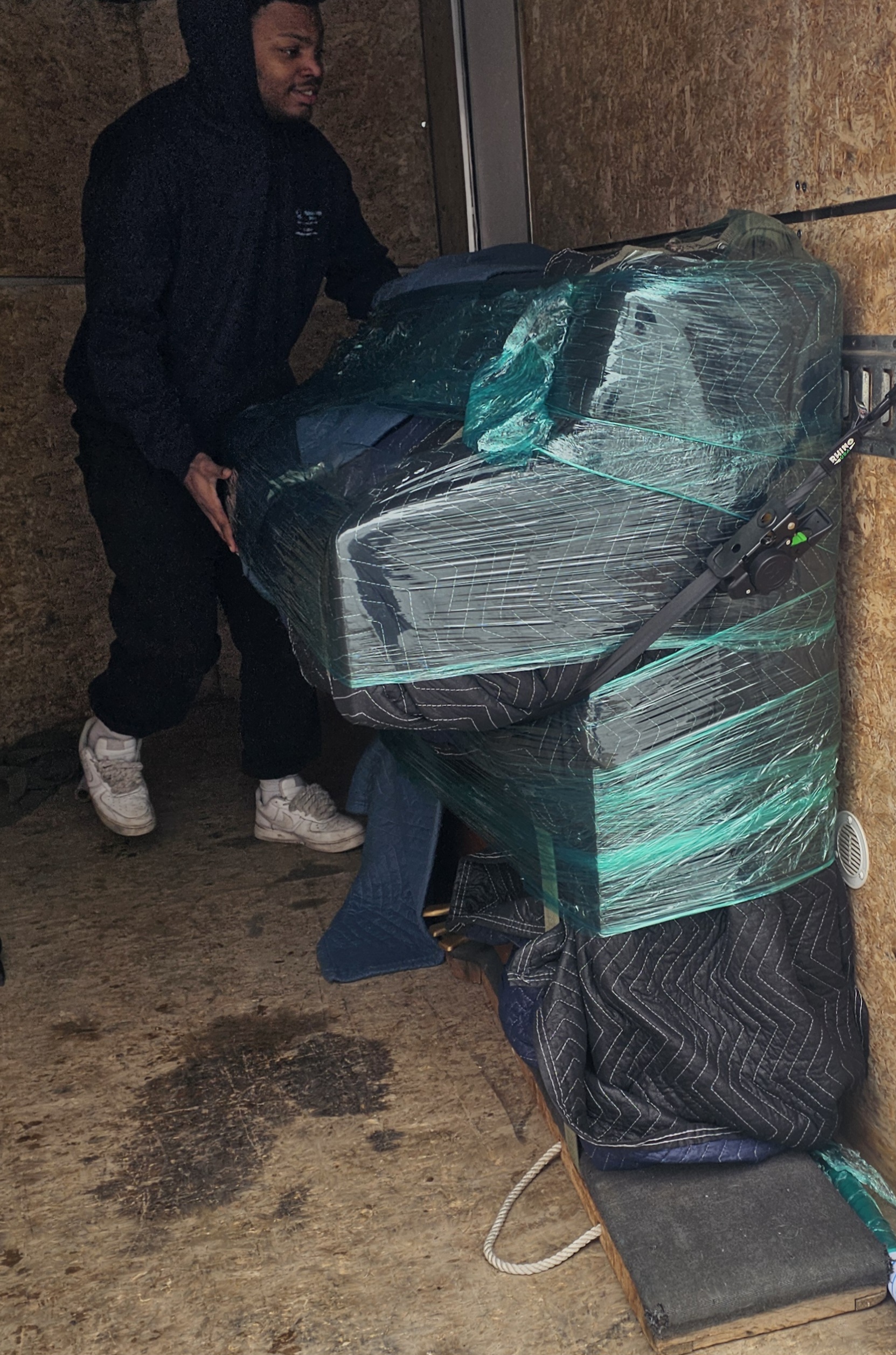 Painless Path Movers crew member carefully securing wrapped furniture inside trailer