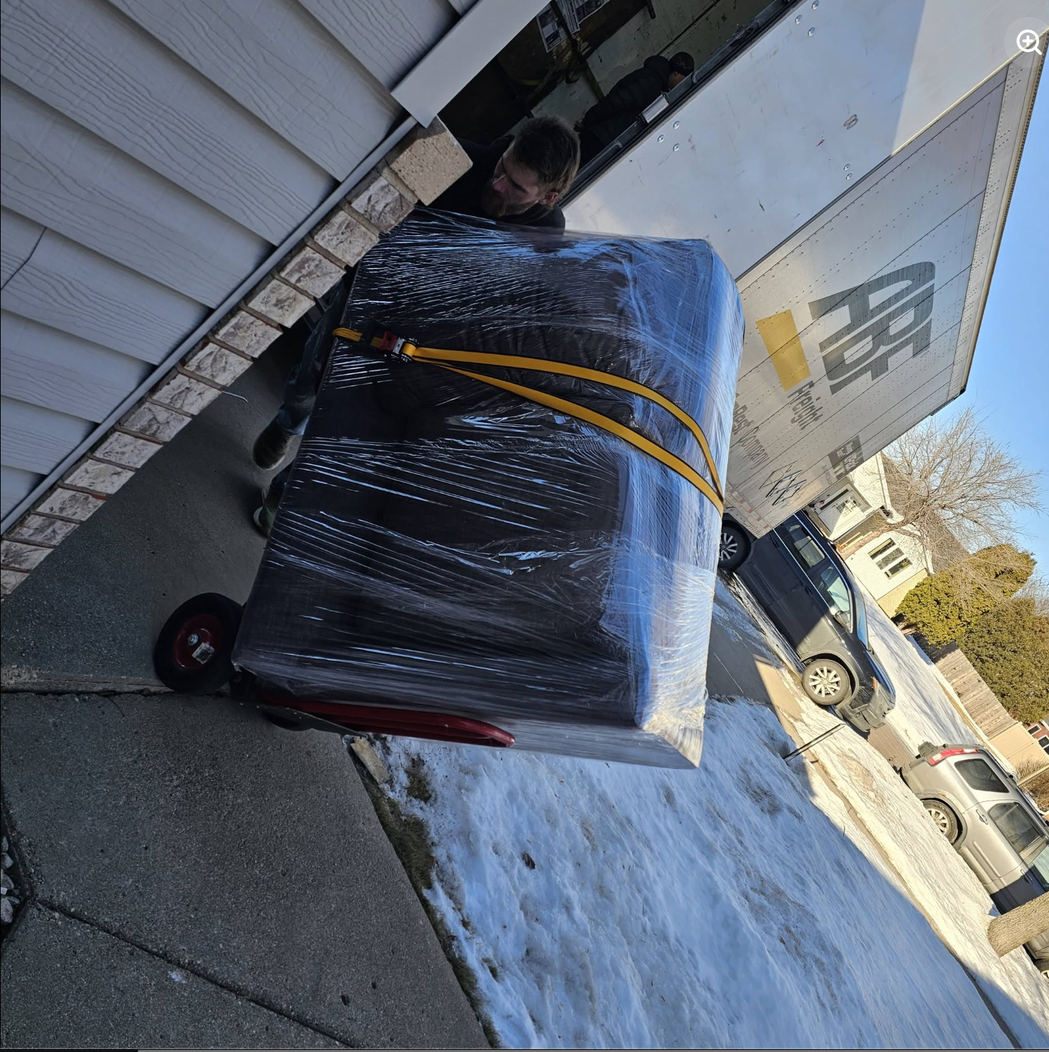 Painless Path mover moving large stretch-wrapped sofa on heavy-duty hand truck dolly outside home