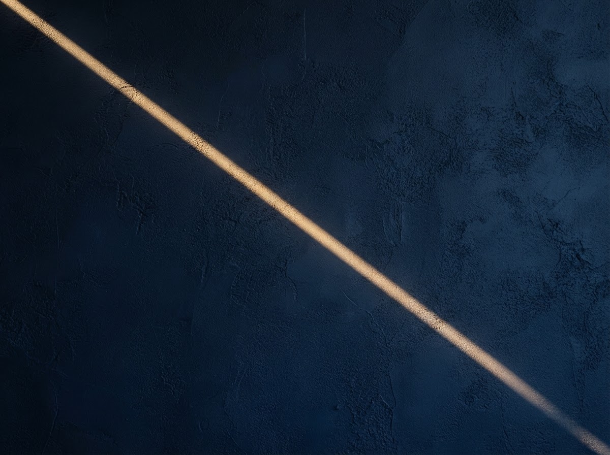 Warm golden light across a deep navy textured surface
