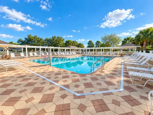 HOA and condo community swimming pool with sun pergolas and lounge chairs