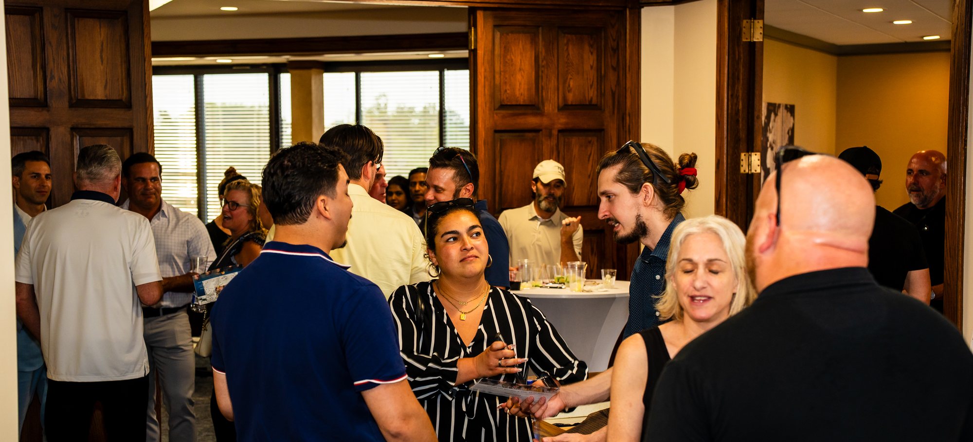 Real estate professionals in conversation at an event in the office
