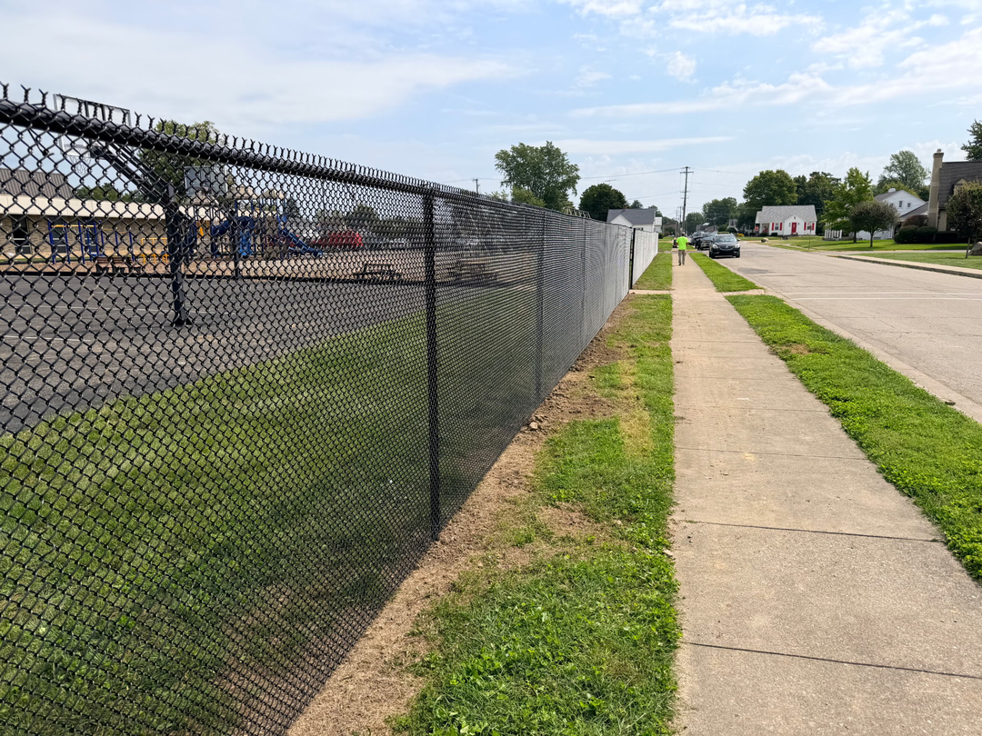 Installed black chain-link fence running along a property line