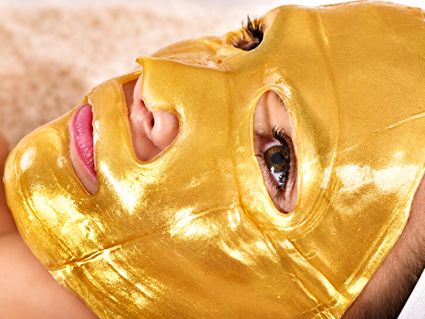 Woman wearing a gold bio-collagen facial mask during a spa treatment