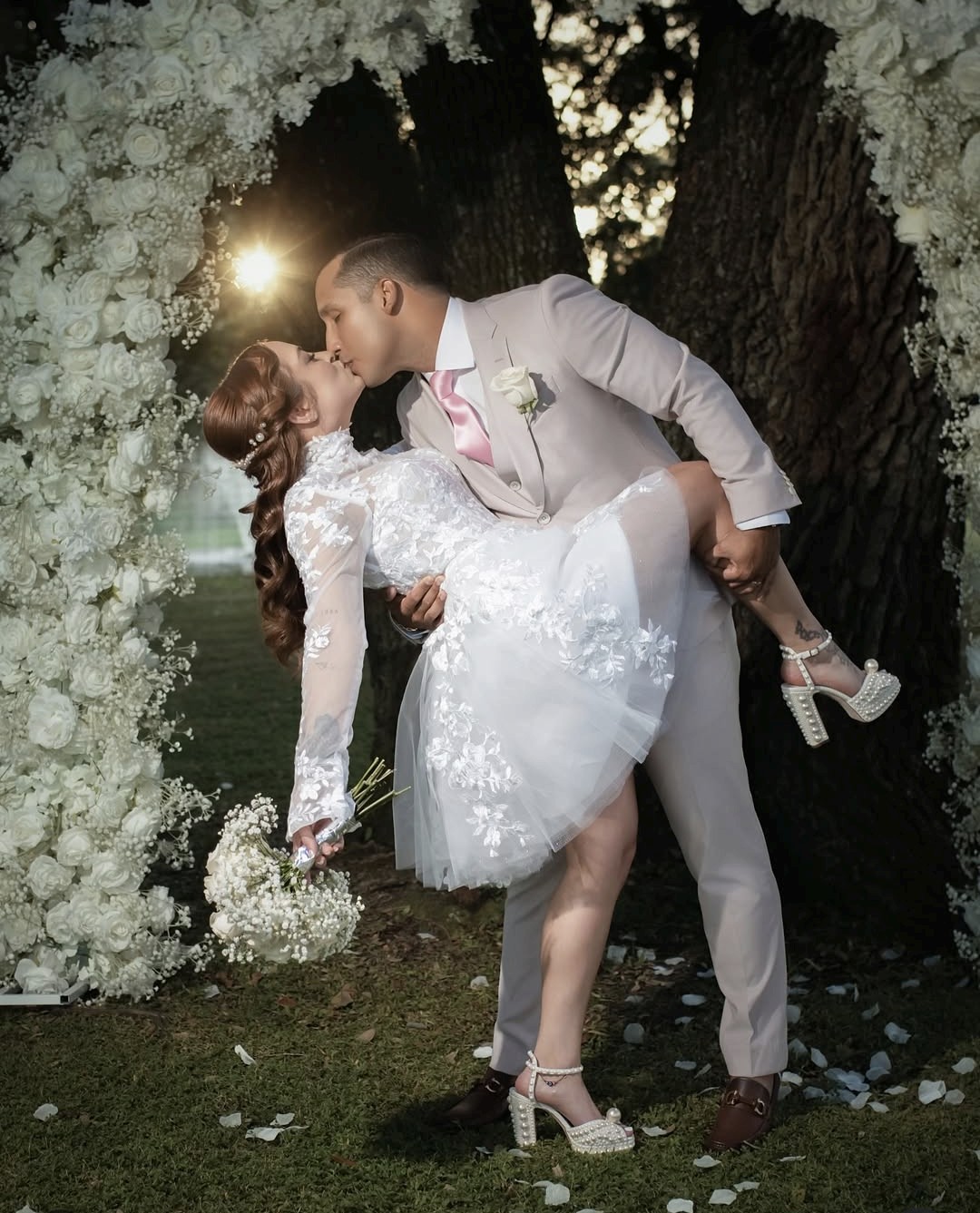 Couple sharing a dip-kiss beneath the oak canopy at a Cespedes Ranch wedding in St. Cloud, FL