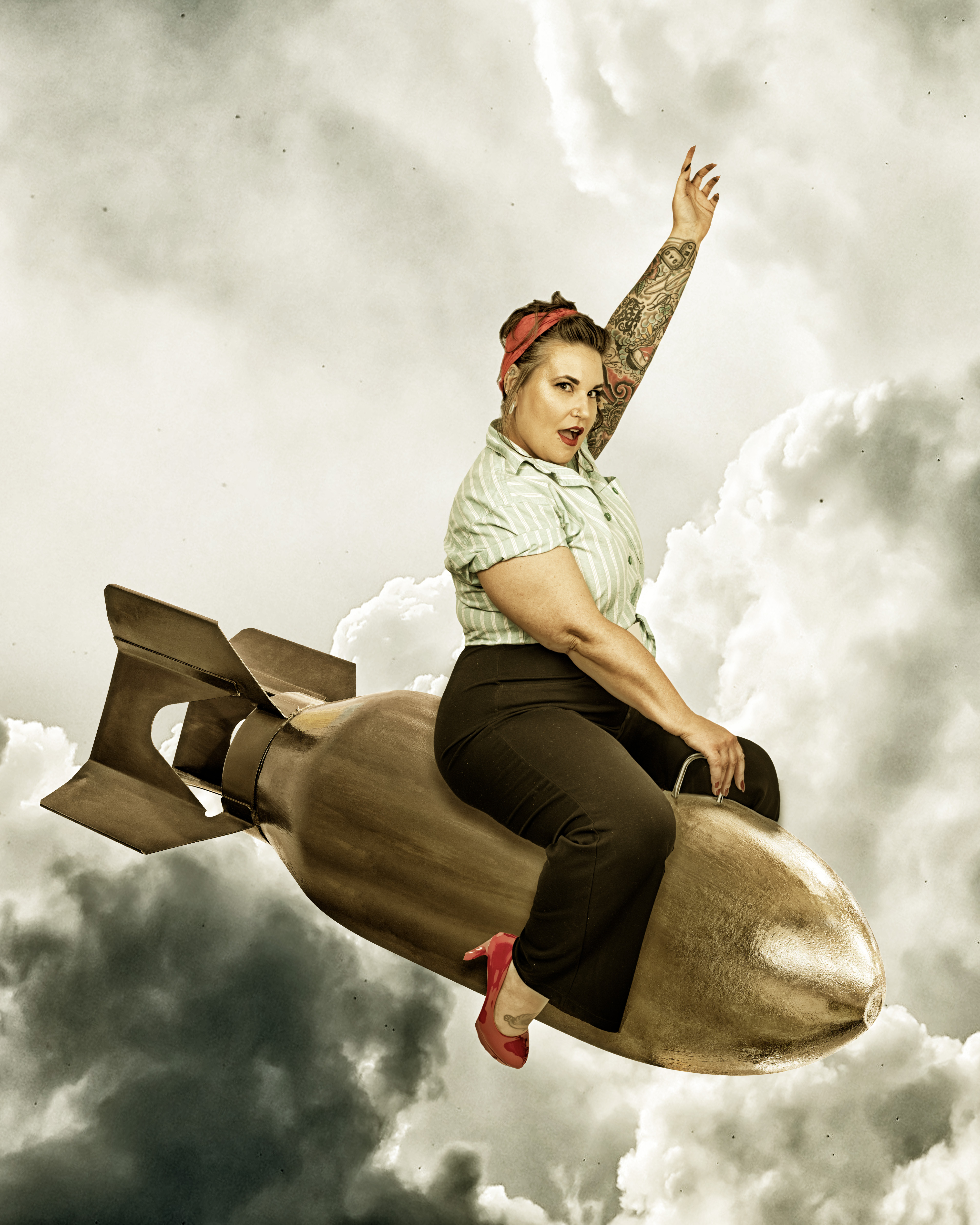 Vintage pin-up bombshell riding a gold bomb through retro cloudscape in red heels and bandana