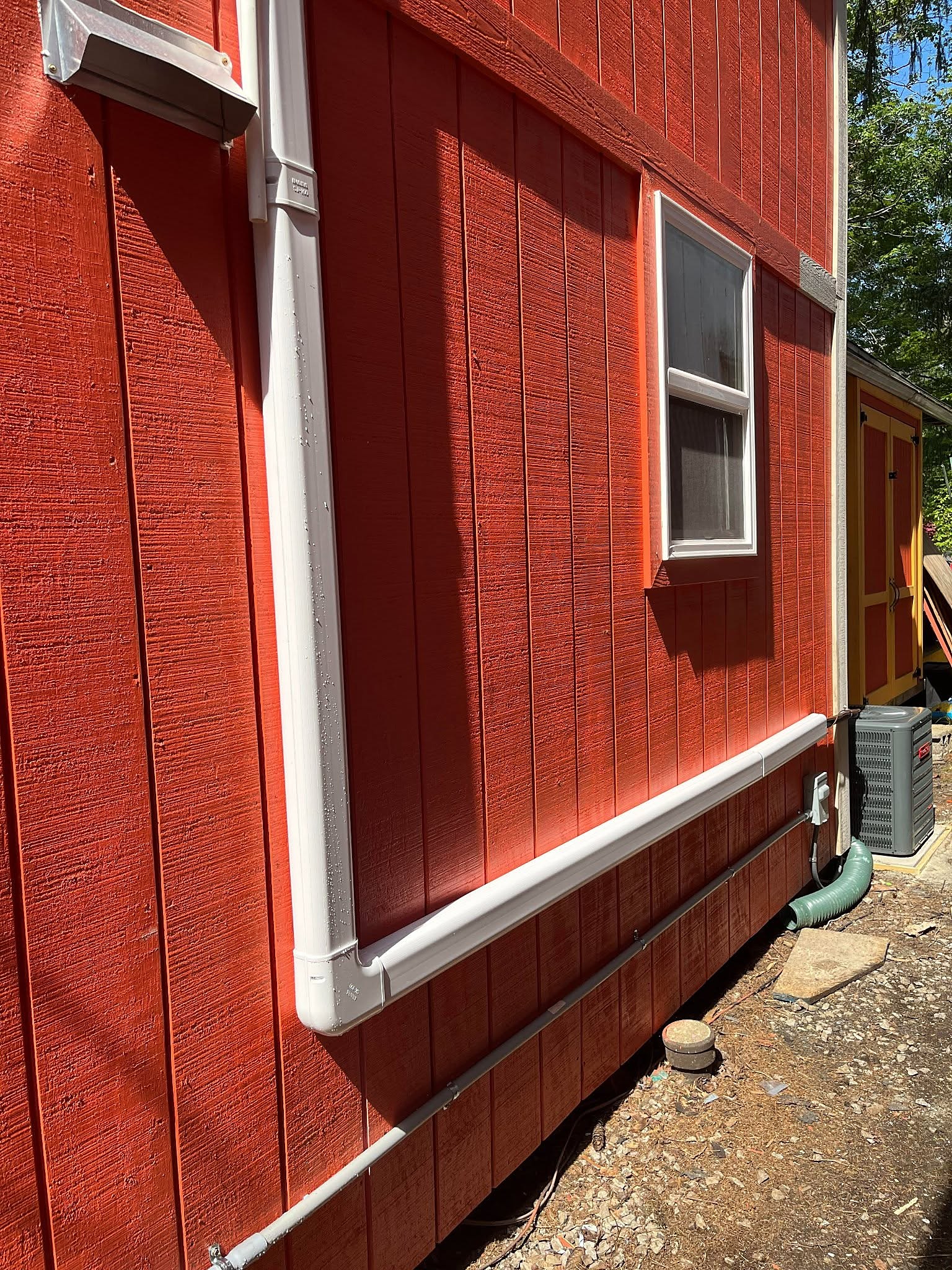 Outdoor unit and covered refrigerant lines on the side of a home