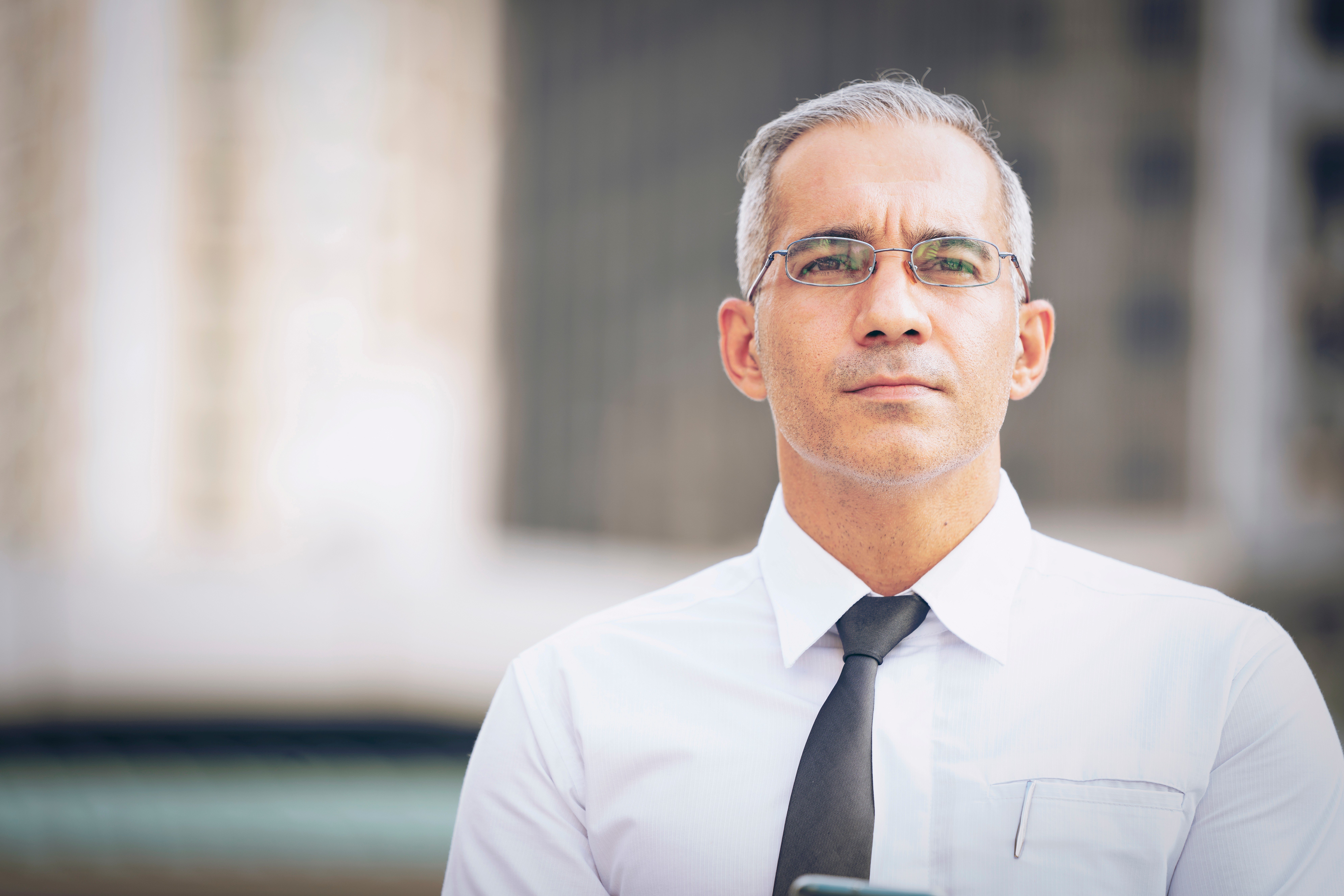 Businessman outside looking thoughtfully into the distance