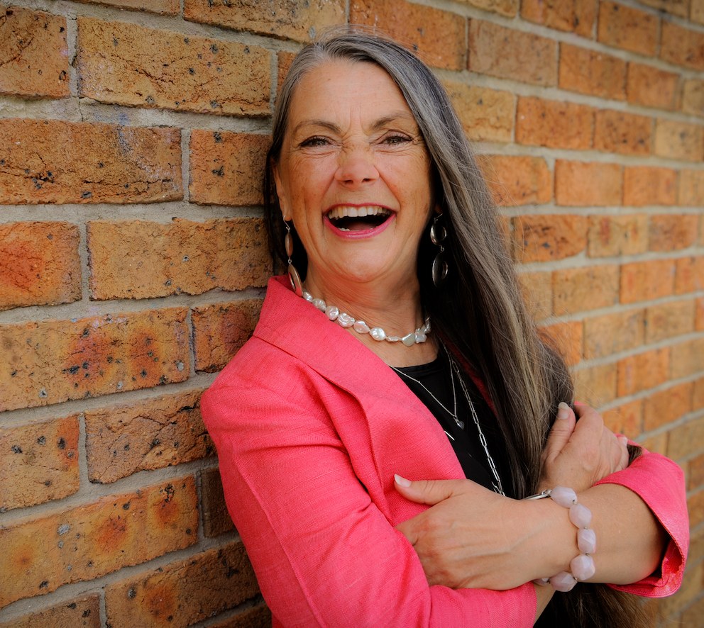 Shari Elle laughing against a brick wall