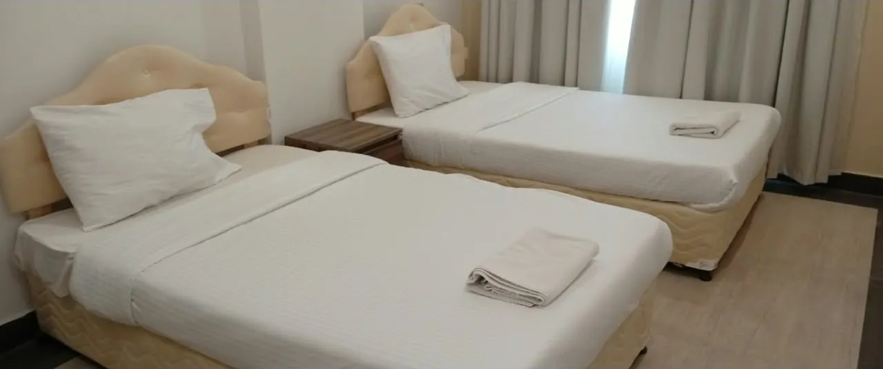 Twin bedroom with two single beds at Royal Hotel Apartments, Al Amerat