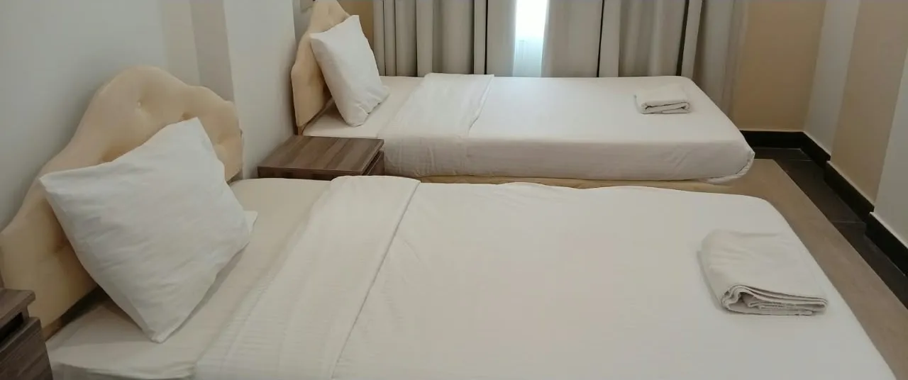 Twin bedroom with two single beds at Royal Hotel Apartments, Al Amerat