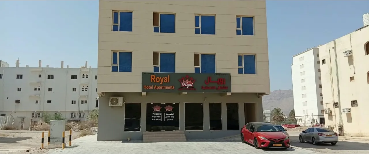 Royal Hotel Apartments building front with entrance and sign, daytime, Al Amerat