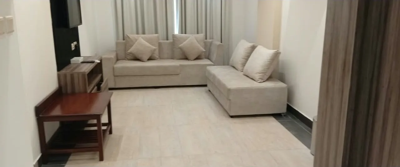 L-shaped sofa living area at Royal Hotel Apartments, Al Amerat