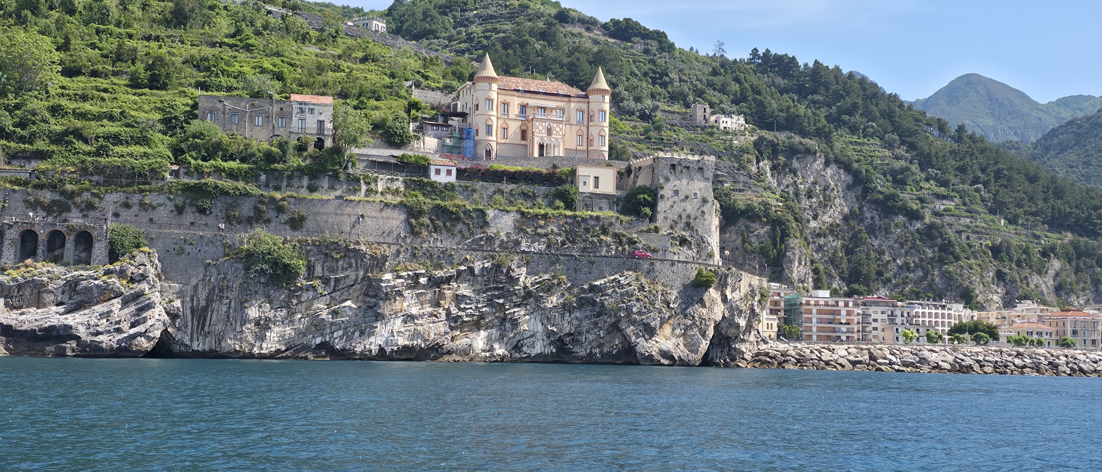 Historic coastal castle and cliffs along the Amalfi Coast seen from the sea
