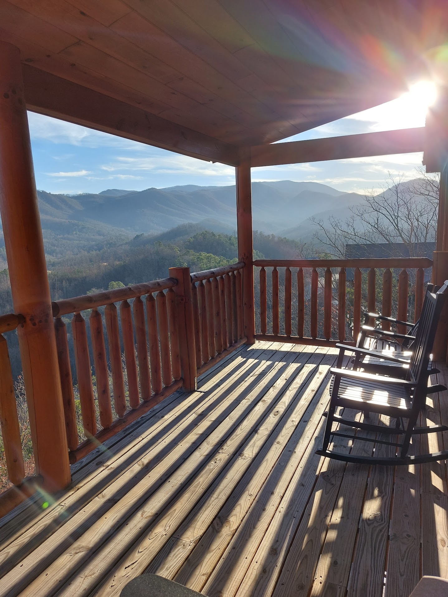 Scenic mountain porch with rocking chairs overlooking misty ridges at sunrise