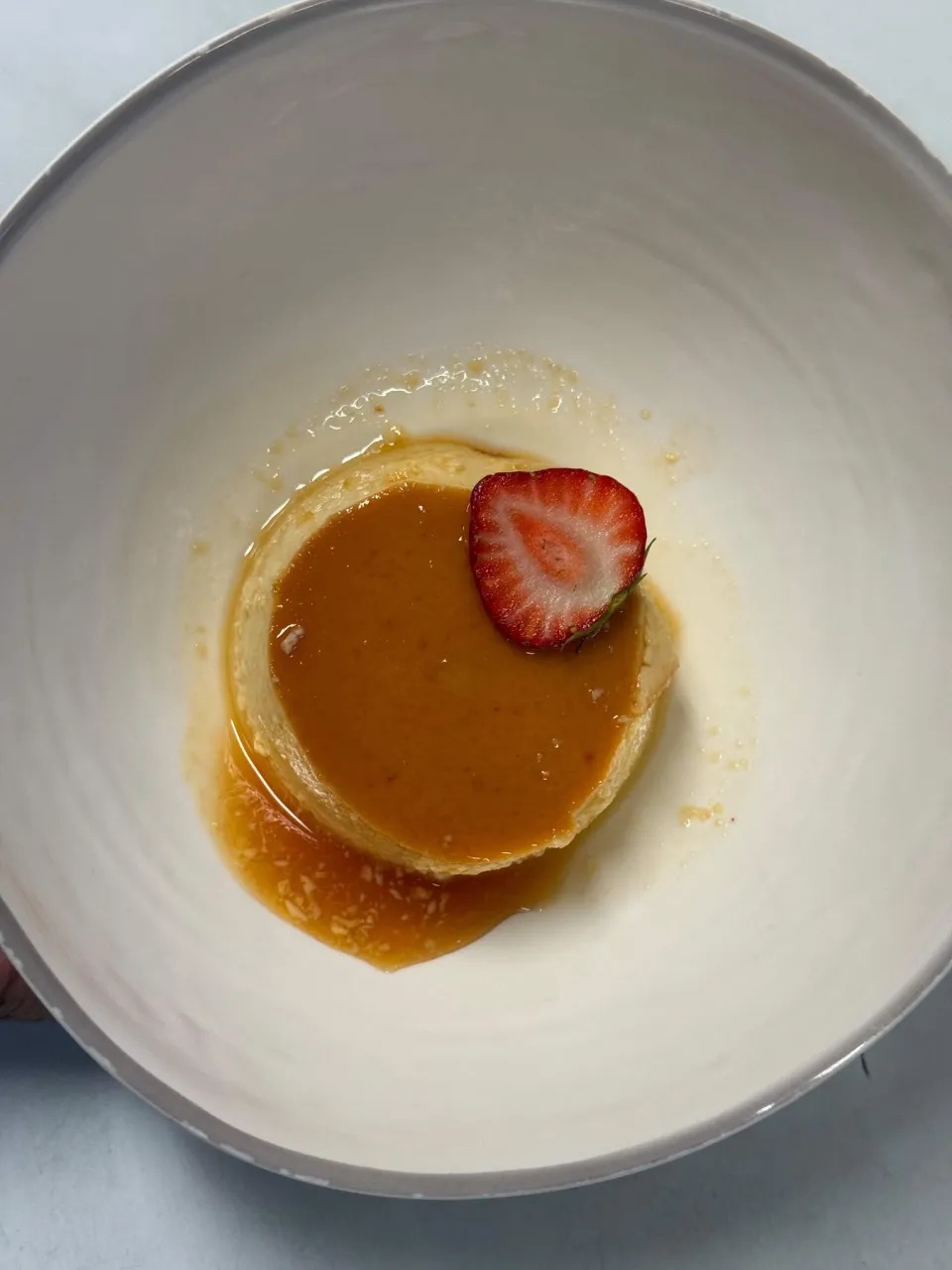 Velvety Caramel Flan with Fresh Sliced Strawberry in Ceramic Bowl