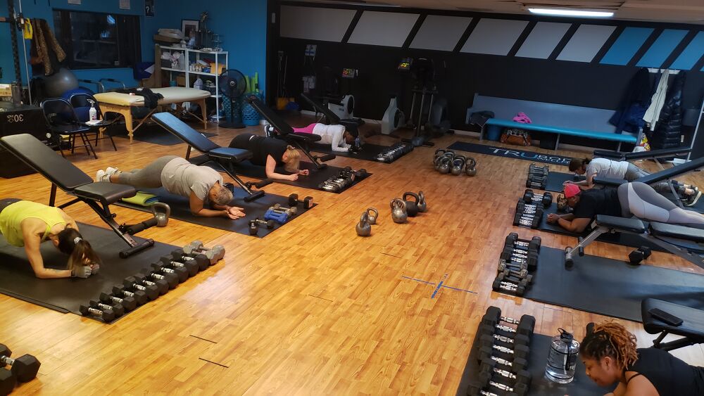 TruBody Wellness indoor facility with turf, weights, and functional training stations