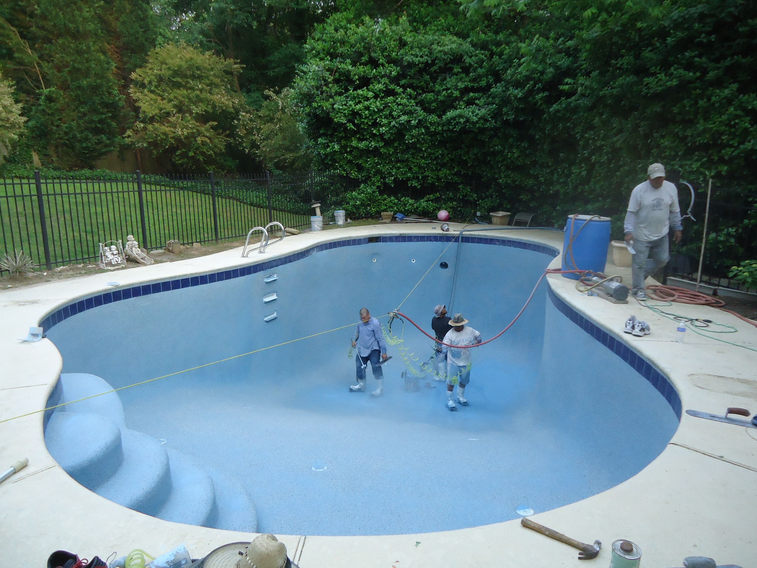 Precision pool-resurfacing project showing the interior-finish application process in a drained swimming pool