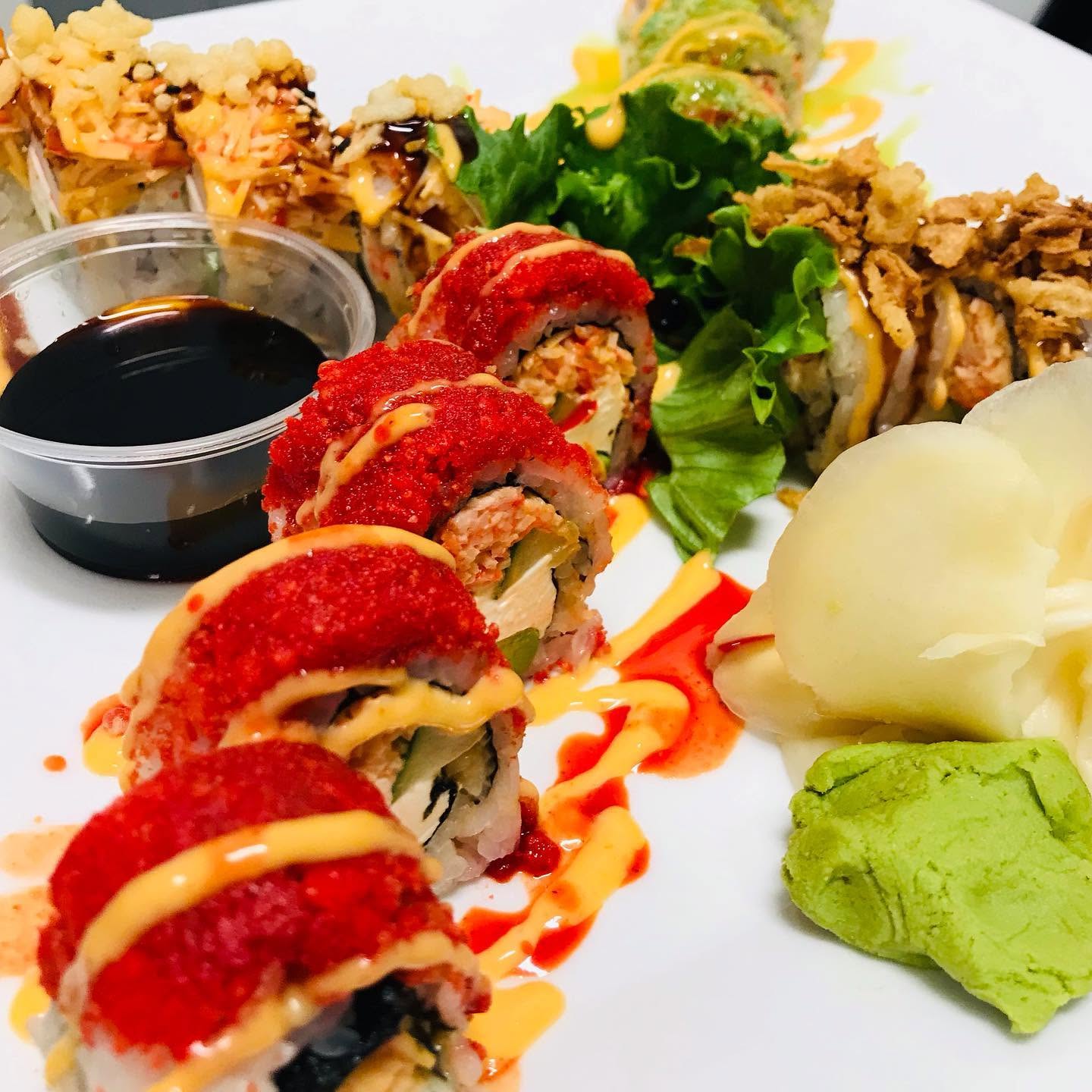 Handcrafted specialty sushi rolls coated with vibrant red masago and spicy aioli with pickled ginger and wasabi at Nori in Omaha