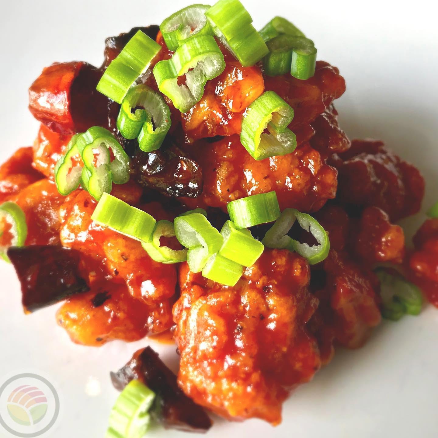 Crispy glazed chicken bites garnished with scallions at Nori sushi restaurant in Omaha