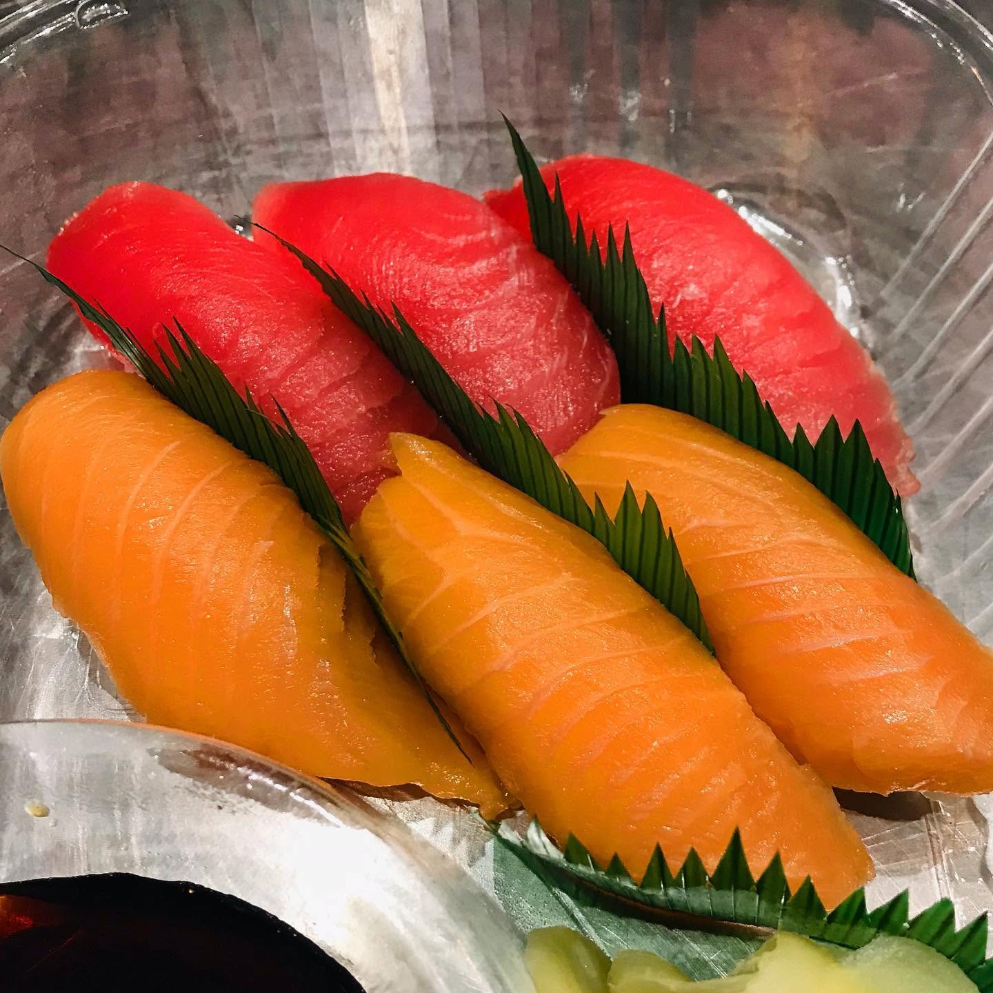 Fresh ahi tuna and salmon nigiri sushi cuts with bamboo leaf garnish at Nori in Omaha