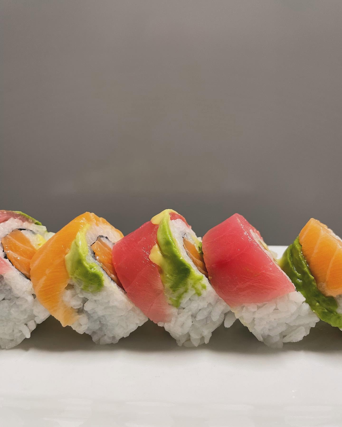 Handcrafted rainbow sushi roll with fresh tuna, salmon, and ripe avocado at Nori in Omaha