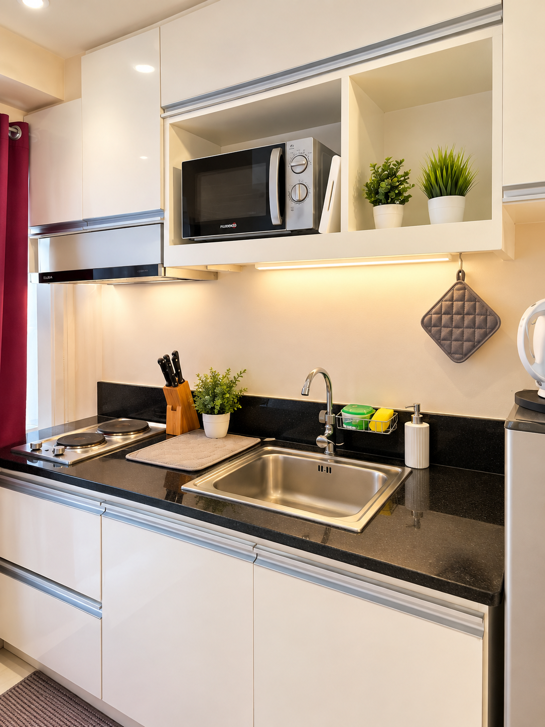 Real Lily Bloom shared kitchen cooking facilities with stove, stainless sink, microwave, and polished countertop