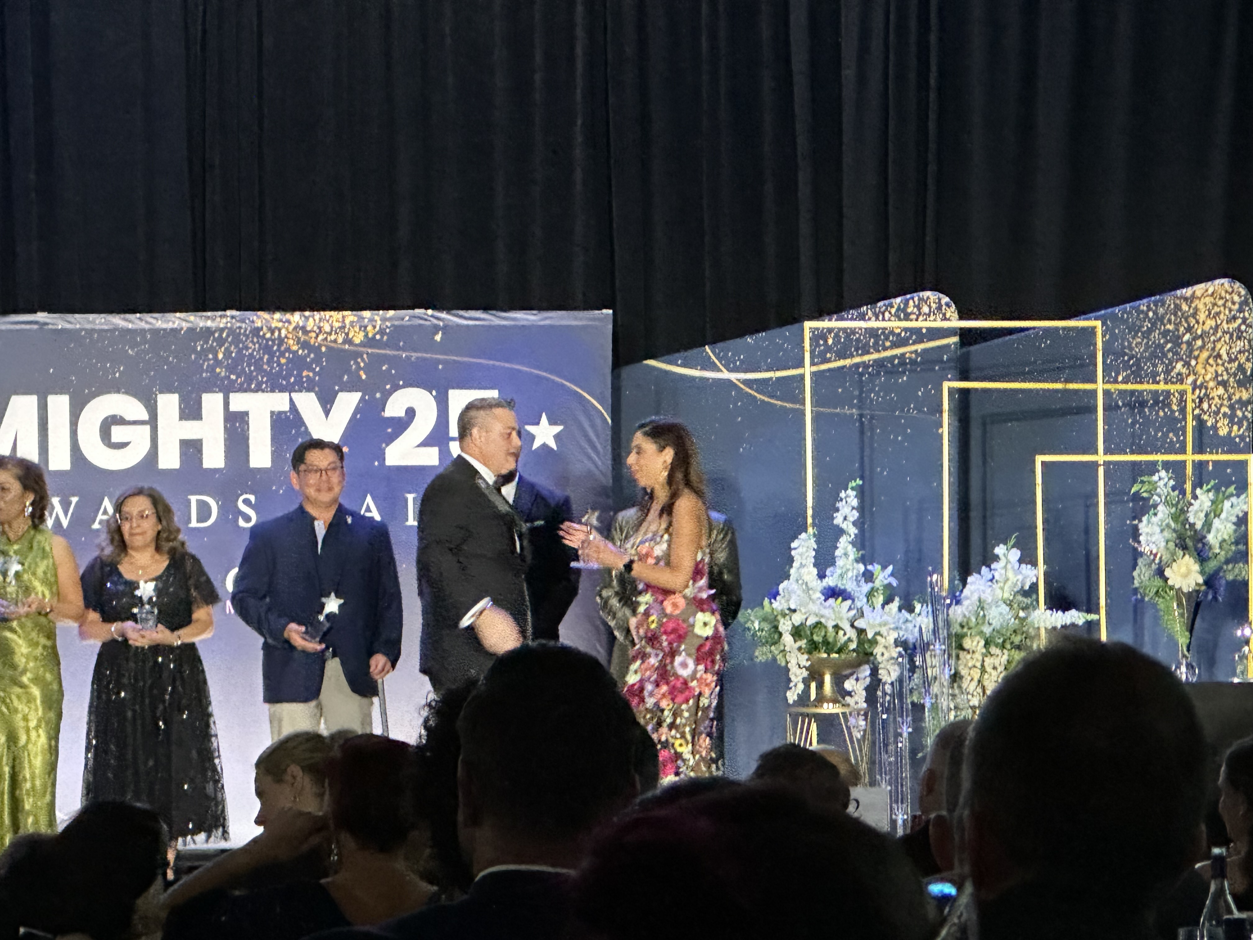 Ryan Patrick Hunt on stage receiving the MIGHTY25 award presentation
