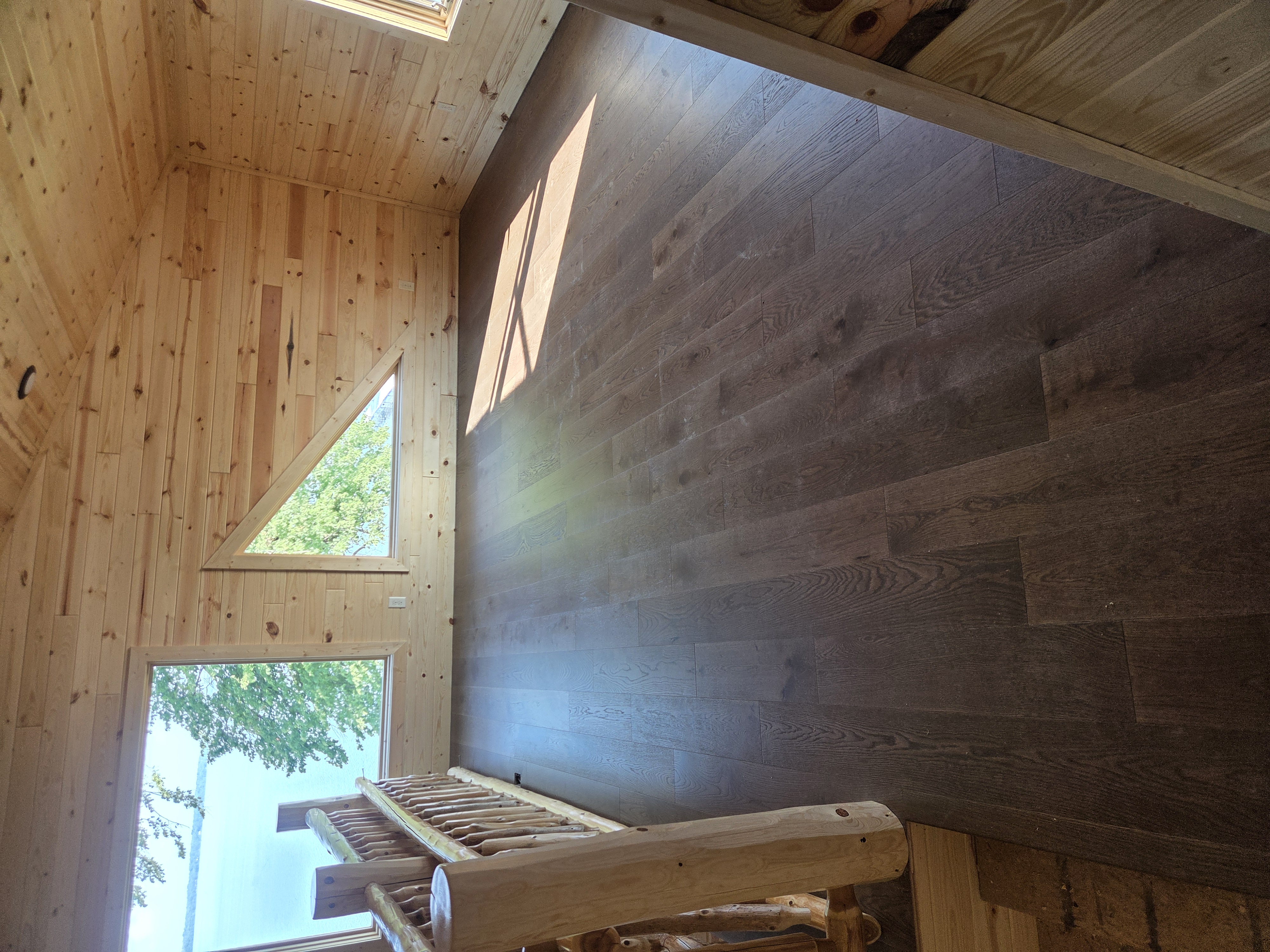 Engineered hardwood flooring beside a stone fireplace
