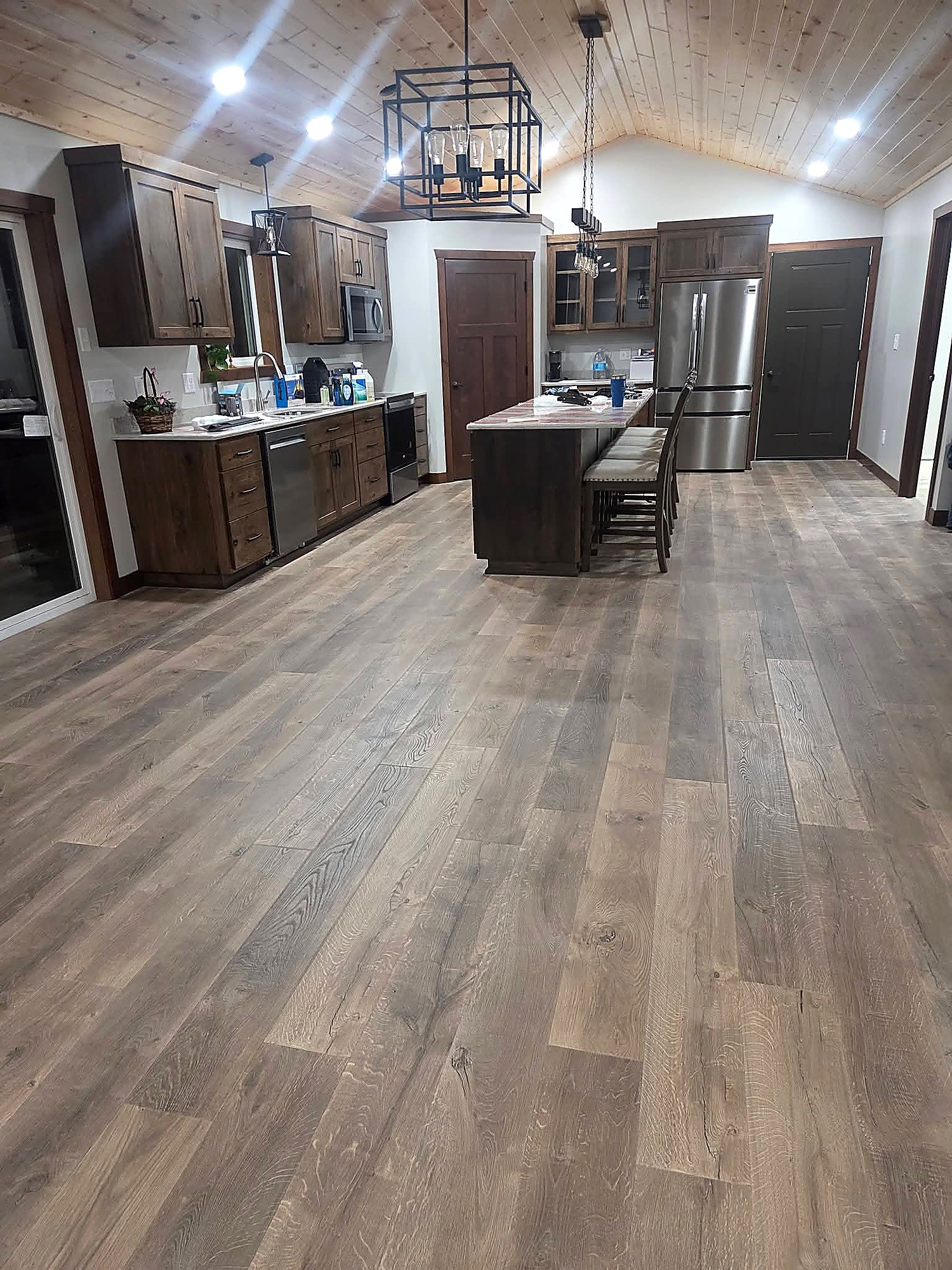Luxury vinyl plank flooring in a finished kitchen with a vaulted ceiling